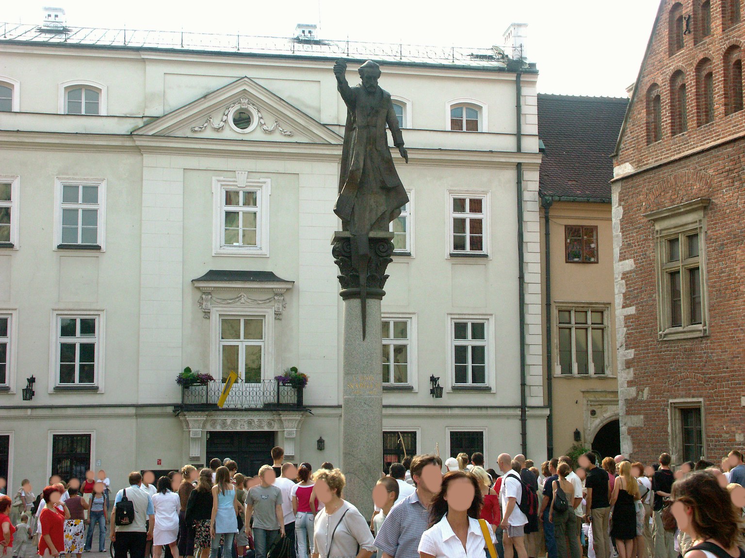 Foule rassemblée sur une place avec une statue et des bâtiments historiques