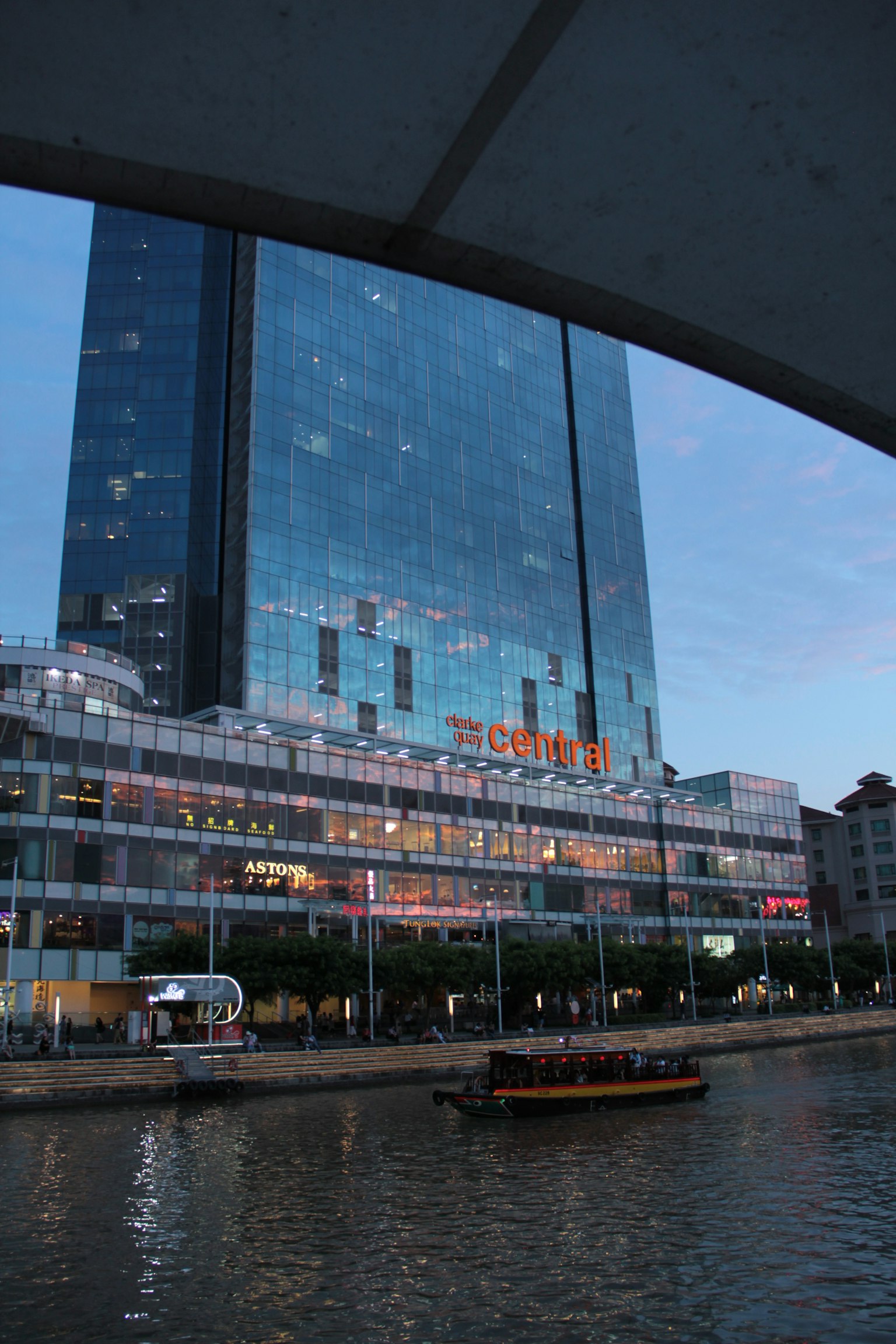 Hochhaus am Fluss bei Dämmerung mit Reflexionen