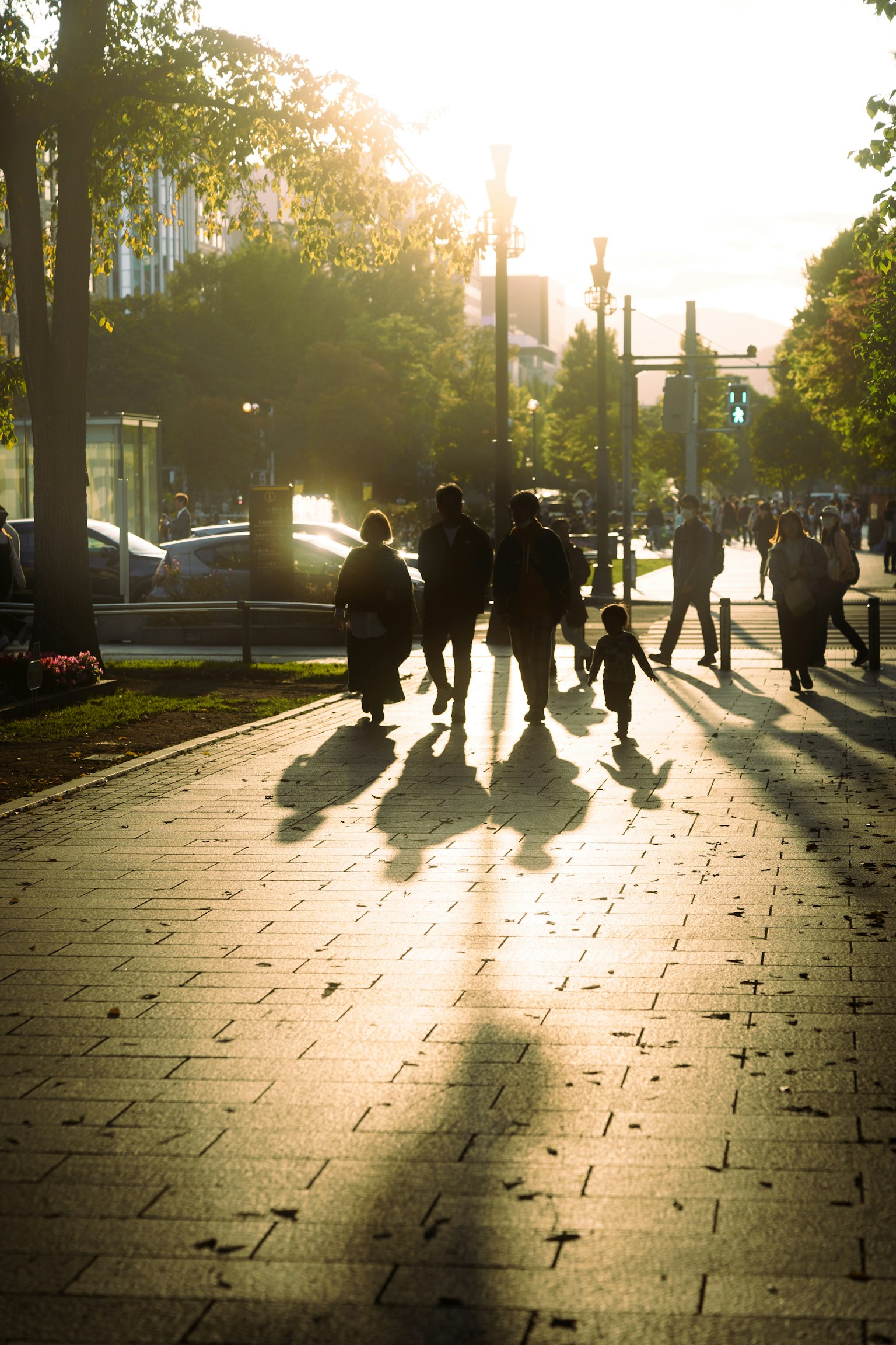 Silhouettes de personnes marchant dans une ville au coucher du soleil