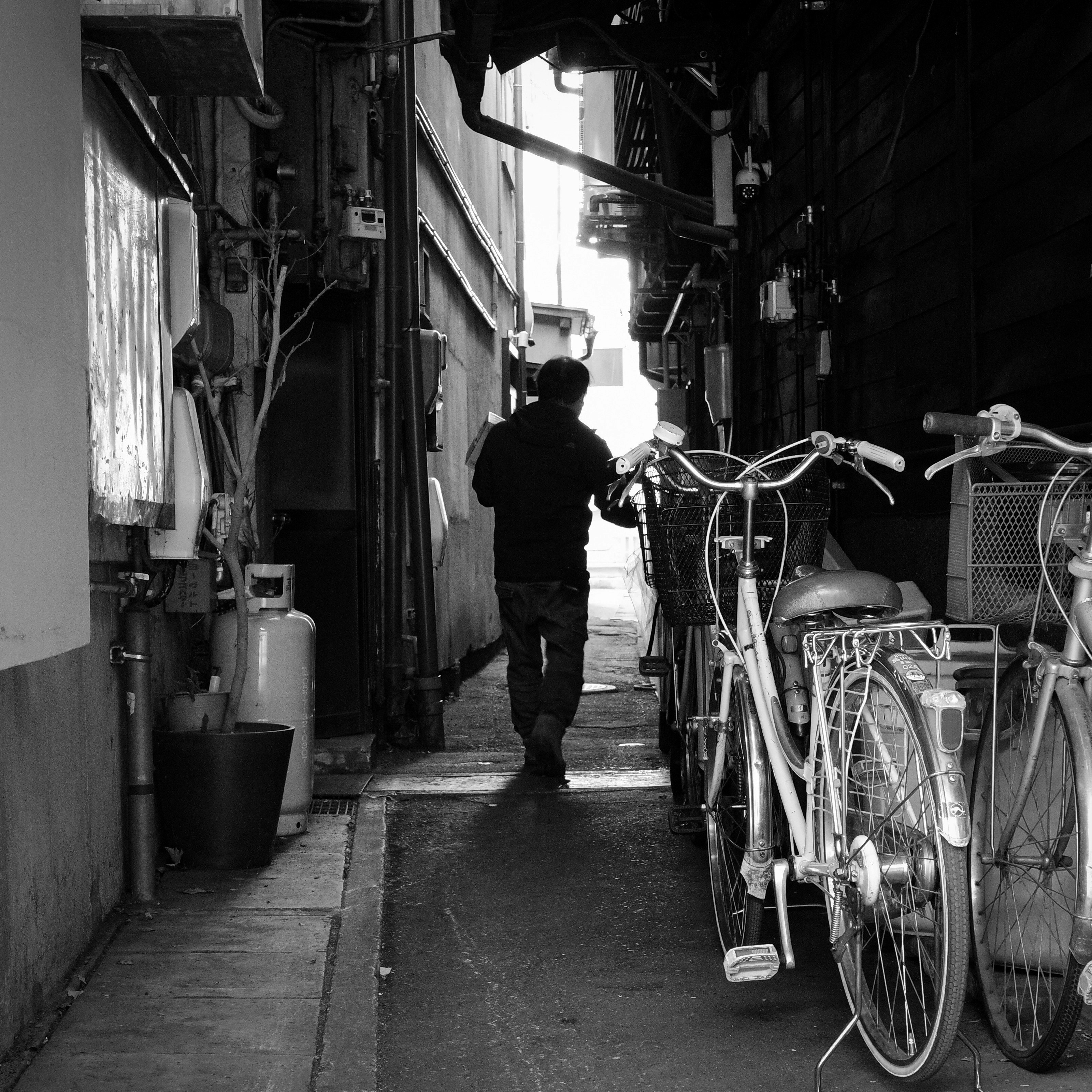 岐阜の路地で自転車が並ぶモノクロの人影シルエット