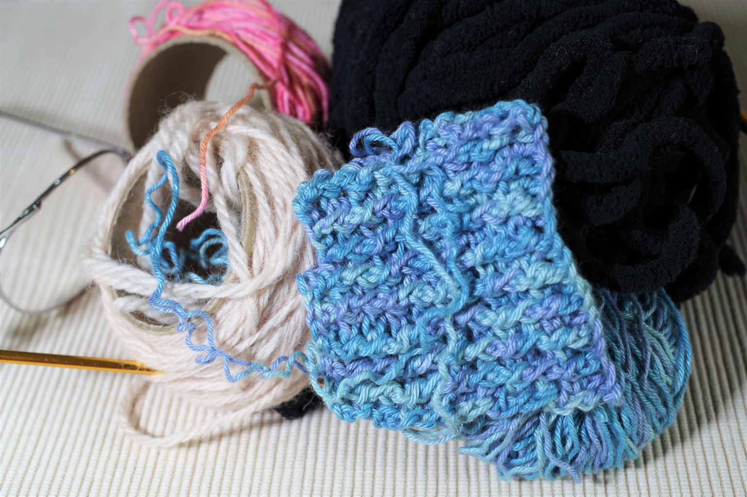 Eine Sammlung von bunten Garnen mit einem teilweise fertigen Strickstück