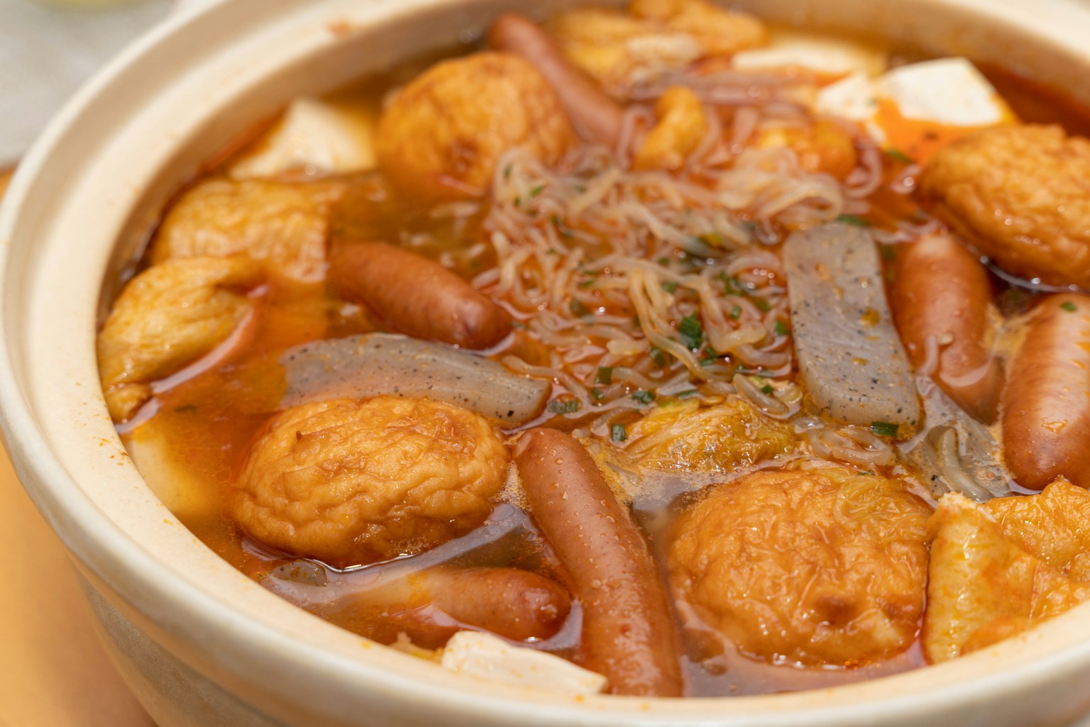 一个热锅里装满了各种配料，包括豆腐和鱼饼