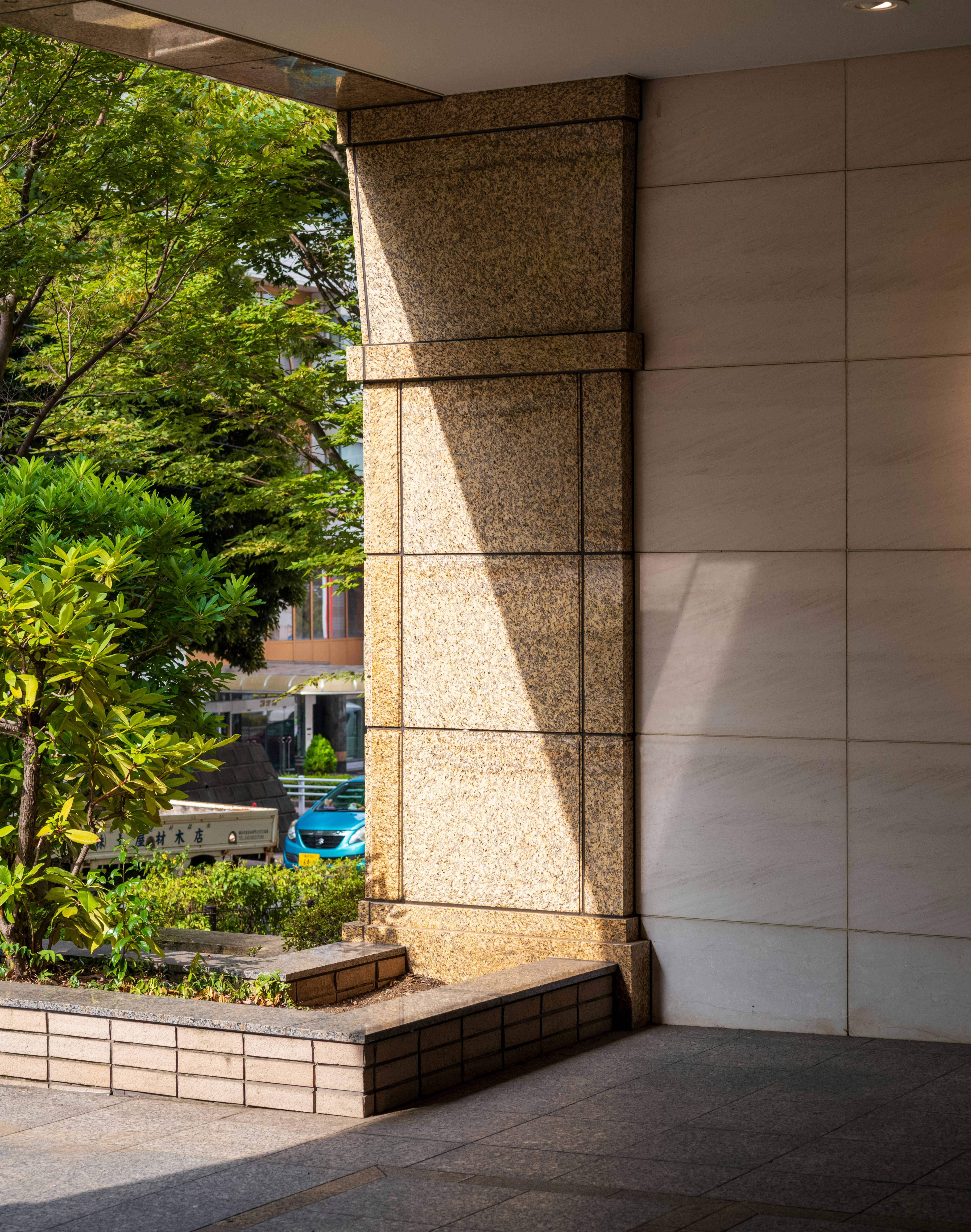 中庭の植栽と石柱のある建物の外観
