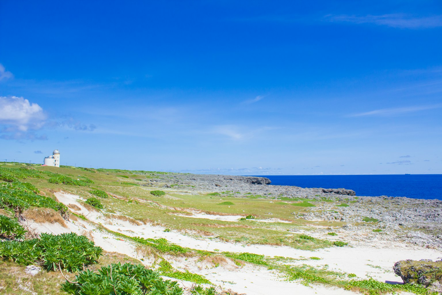 被蓝天和海洋环绕的海岸风景 远处有一座灯塔