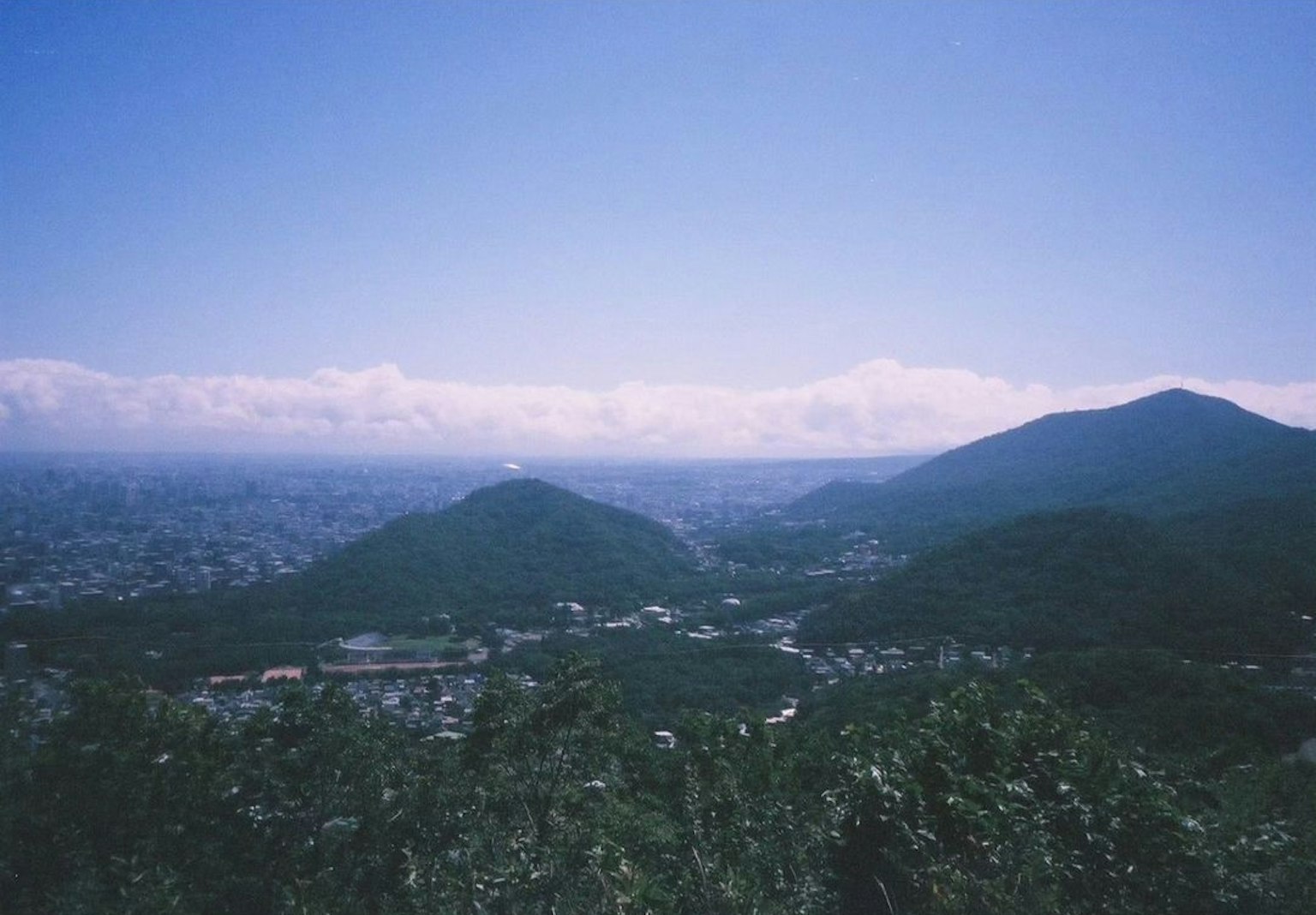 Vista escénica de montañas bajo un cielo azul con nubes flotantes