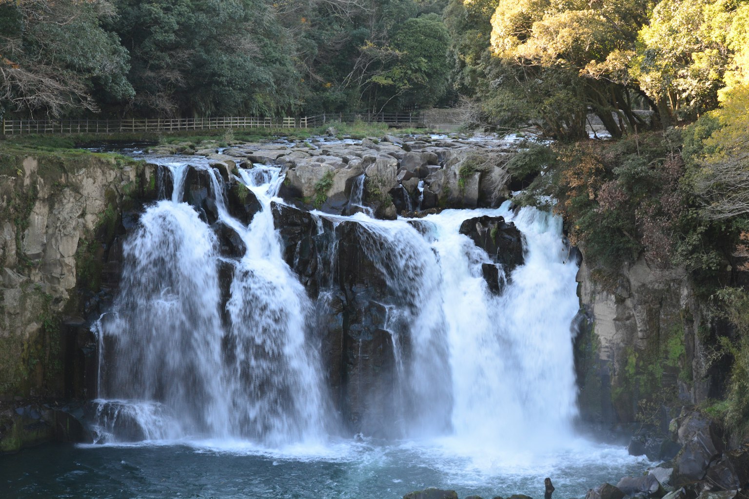 A beautiful waterfall cascading in a serene landscape surrounded by lush greenery