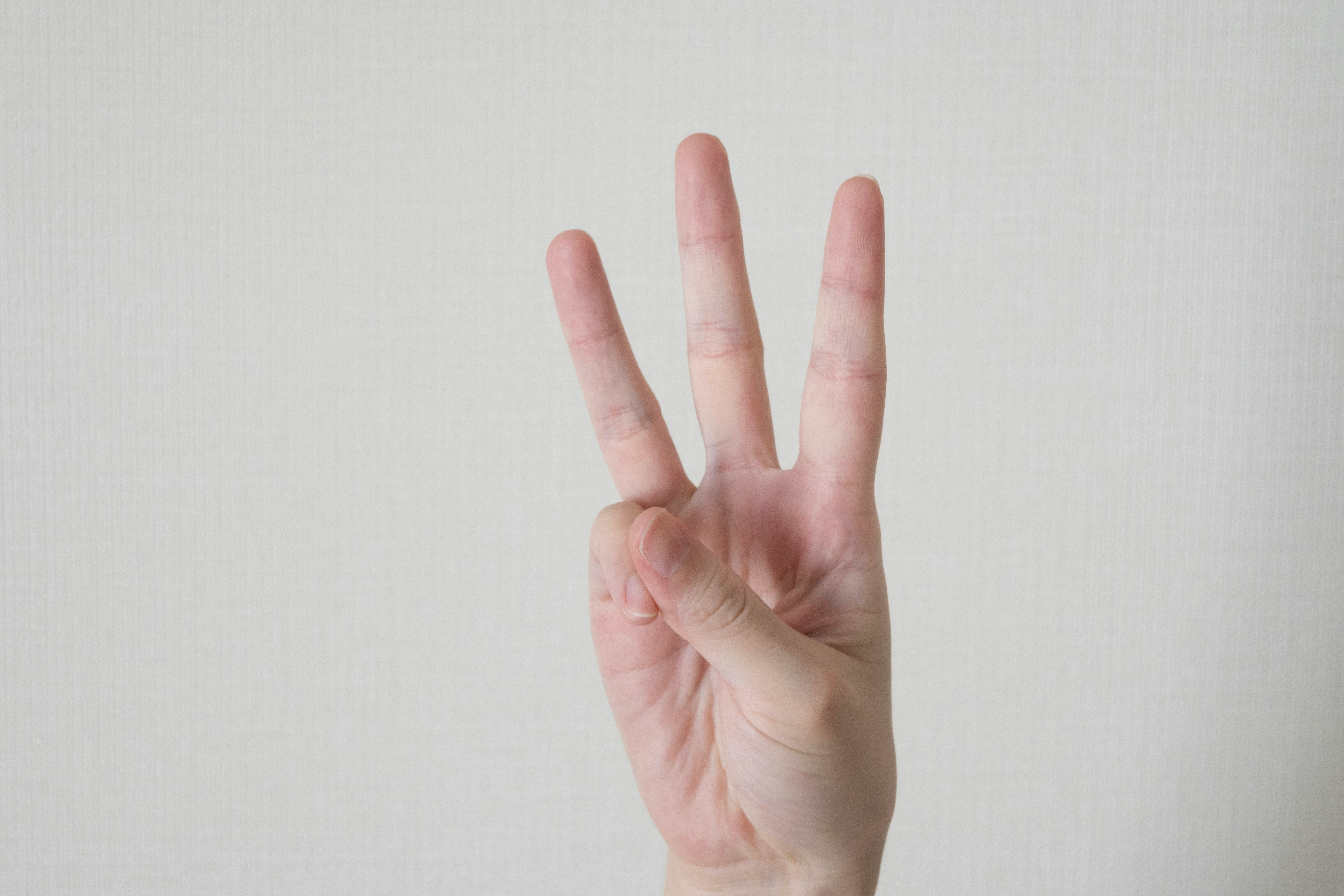 Hand gesture with an open palm against a white background