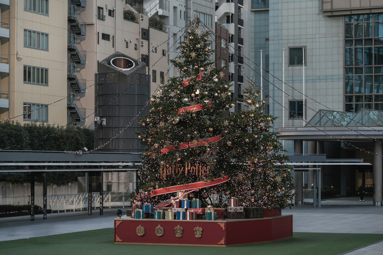 Arbre de Noël décoré de lumières et de cadeaux dans une place urbaine