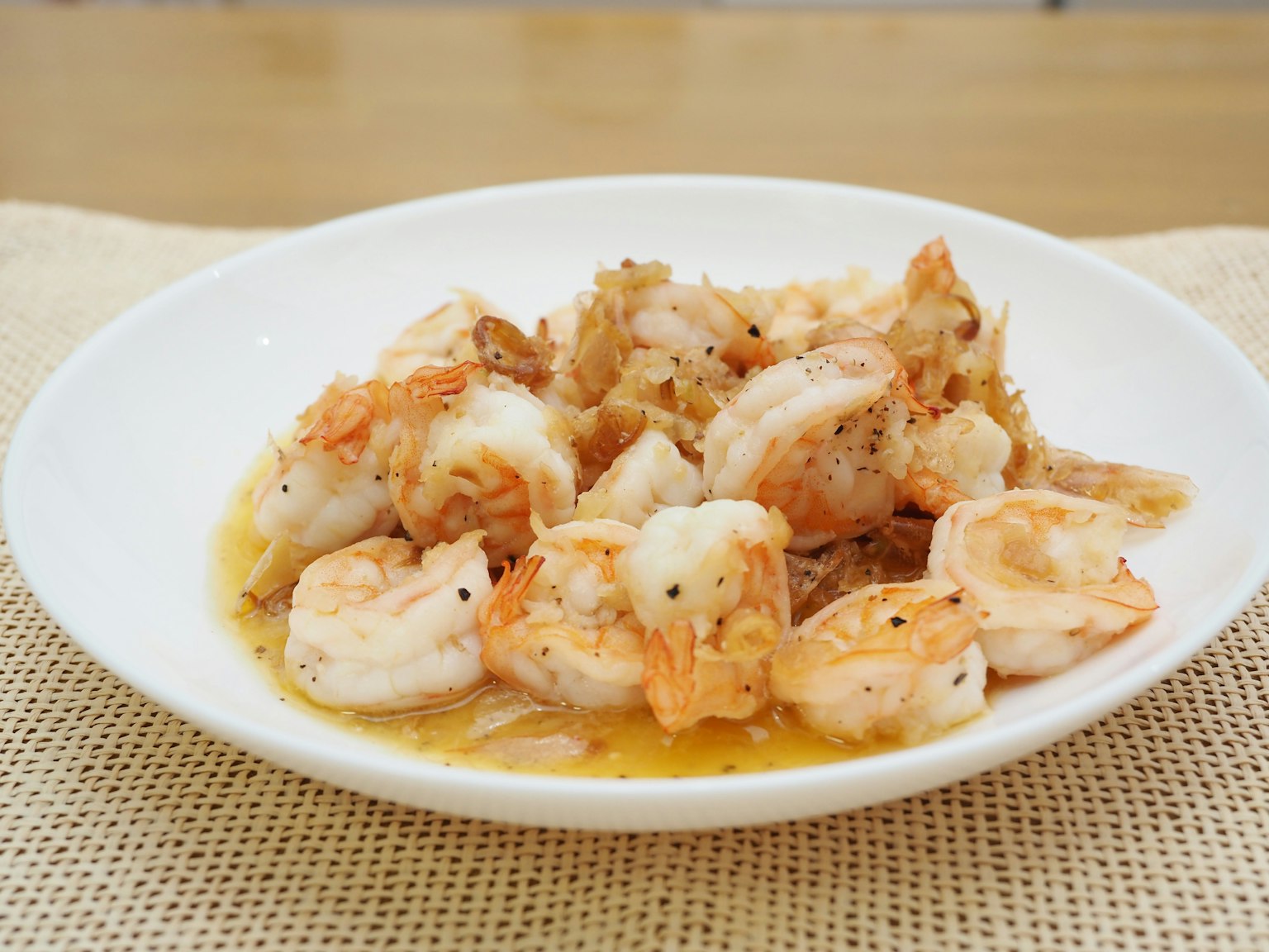 Shrimp dish served on a white plate with a flavorful sauce