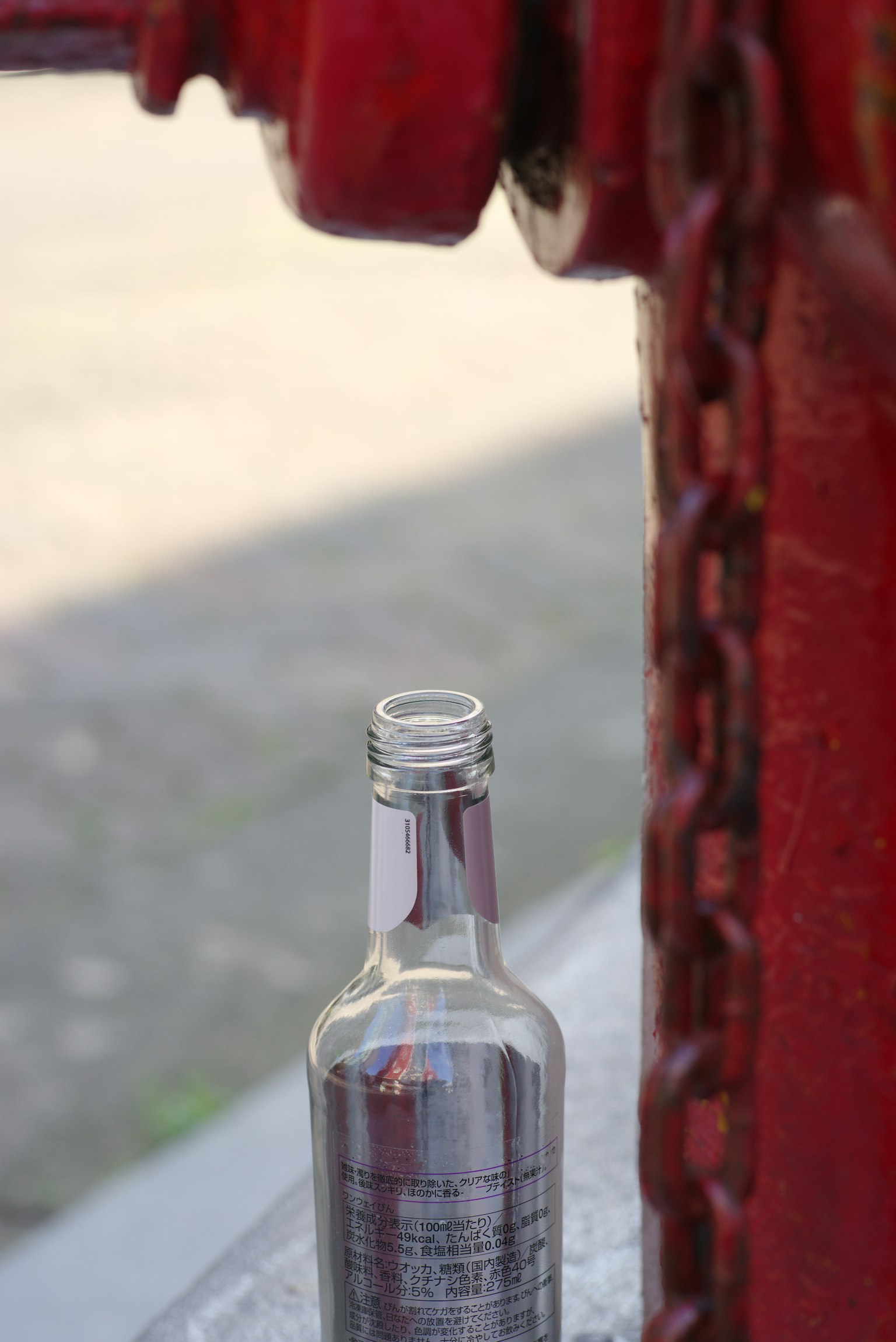 Imagen en primer plano de una botella junto a una cadena roja