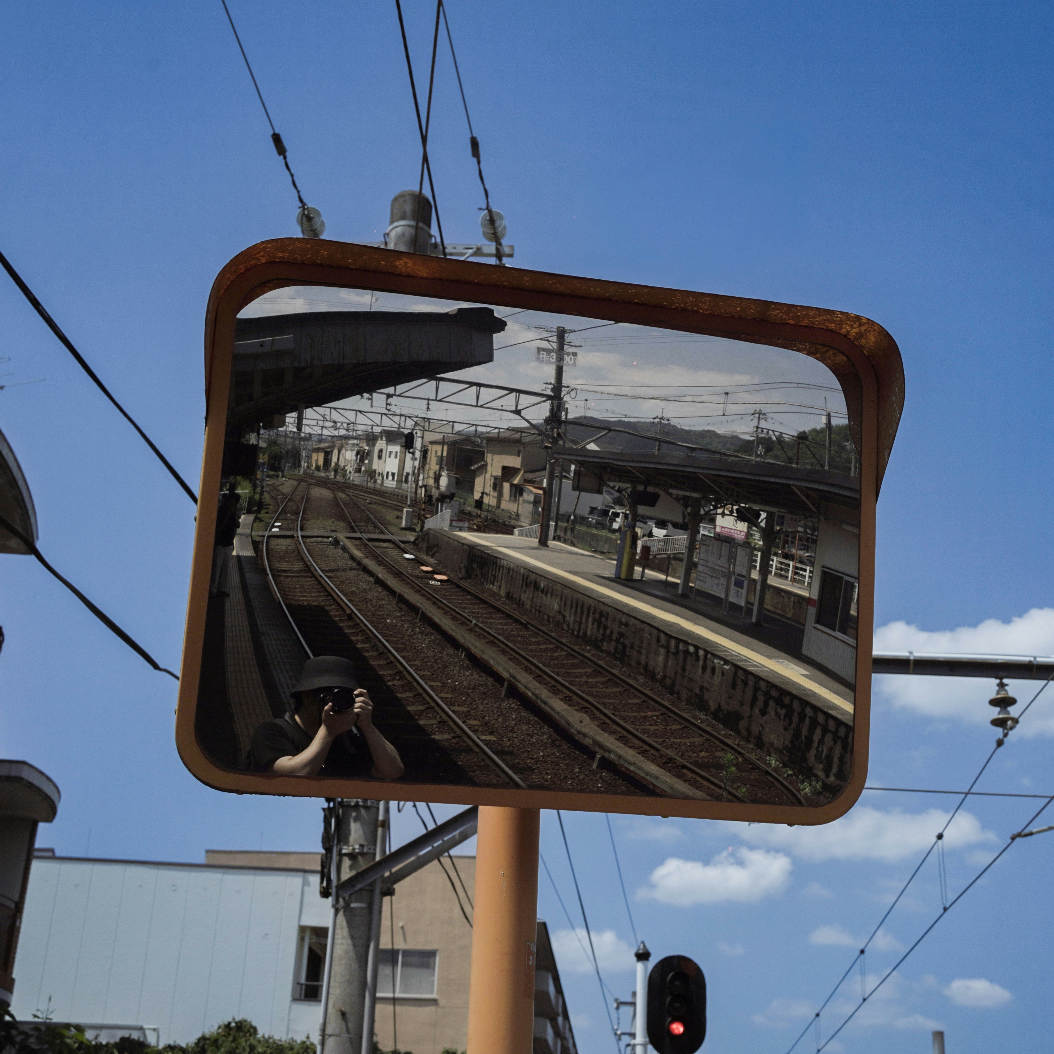 線路とホームが映る車窓のミラー画像
