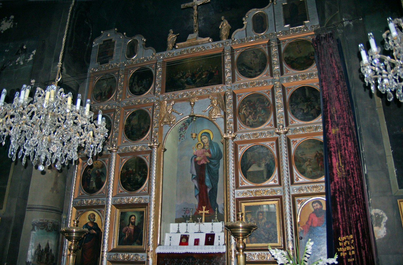 Intérieur d'une église avec un autel orné de décorations dorées et de nombreuses icônes religieuses