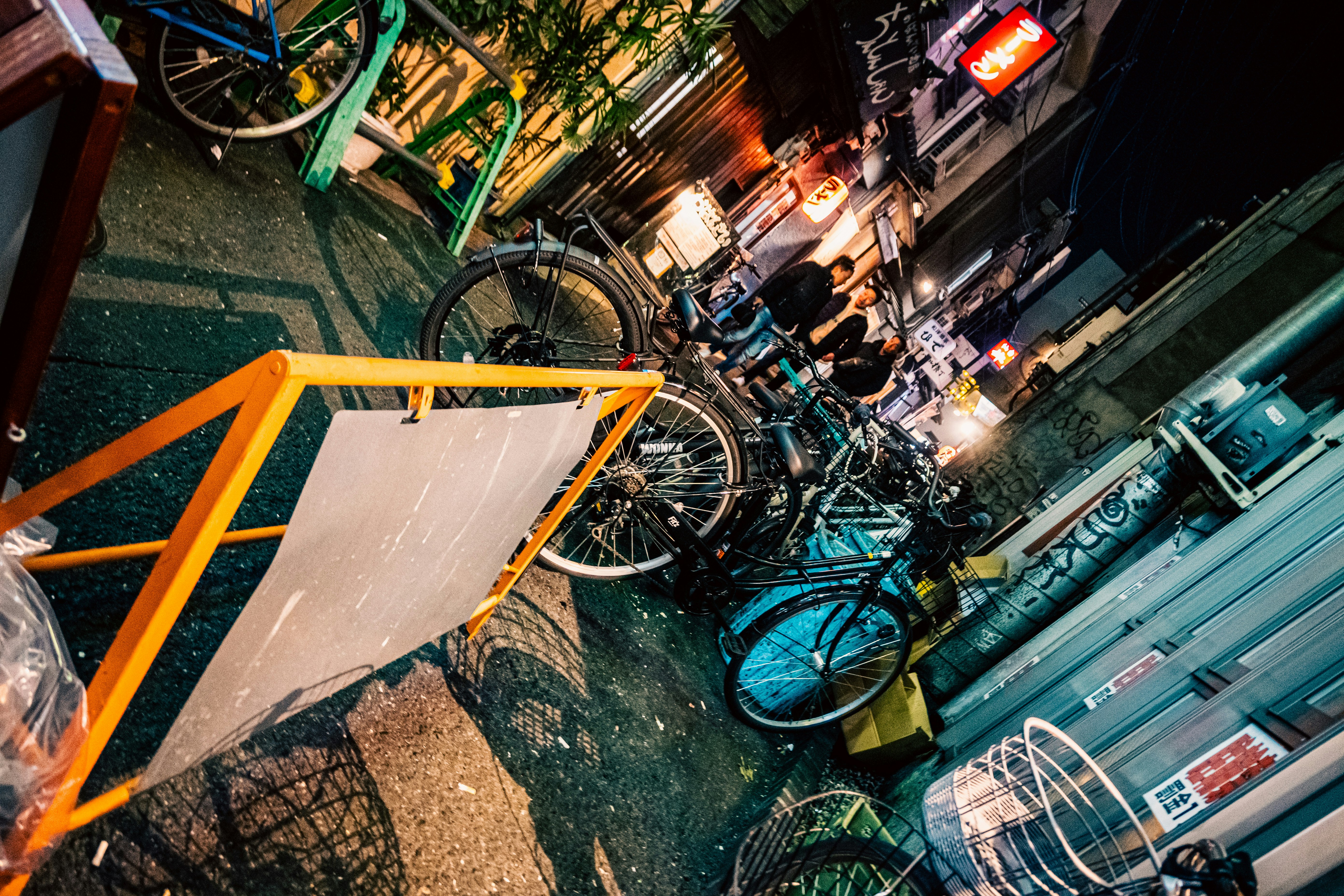 路地に並ぶ自転車と店先の看板