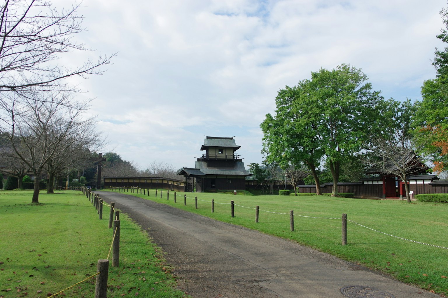 Japanese castle view surrounded by lush green grass and a path