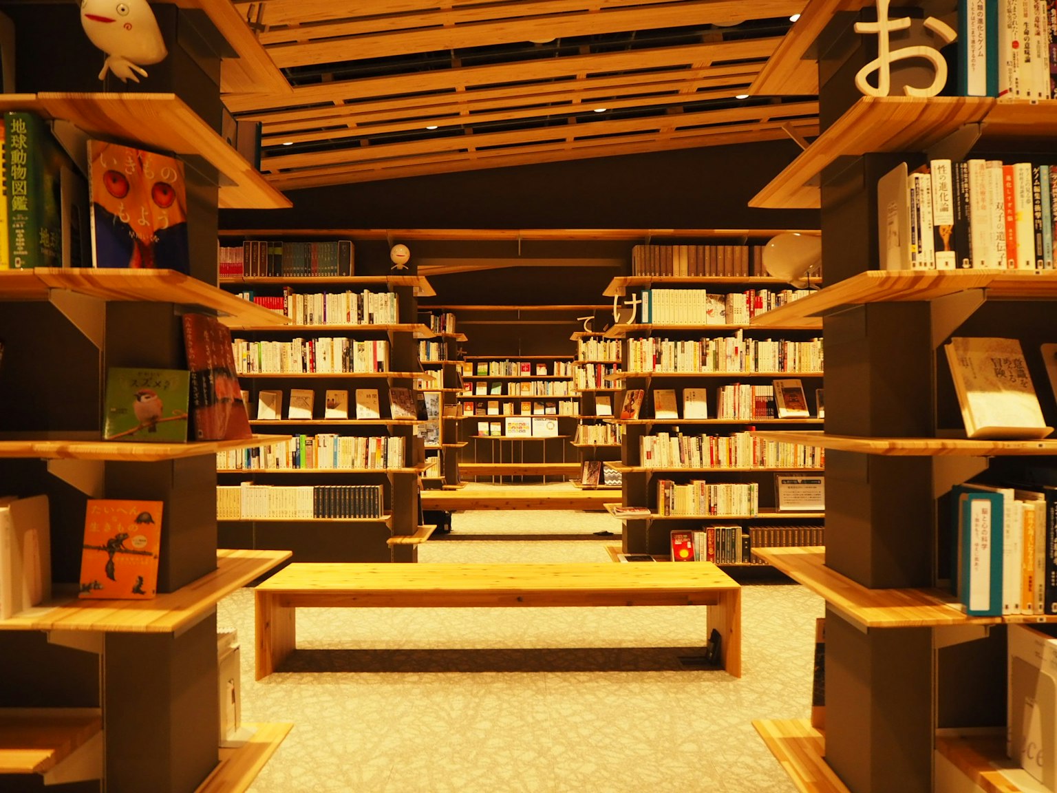 Interior of a modern bookstore with shelves of books and wooden tables