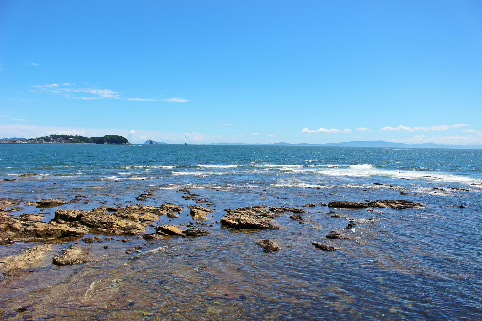 Pemandangan laut biru dengan pantai berbatu