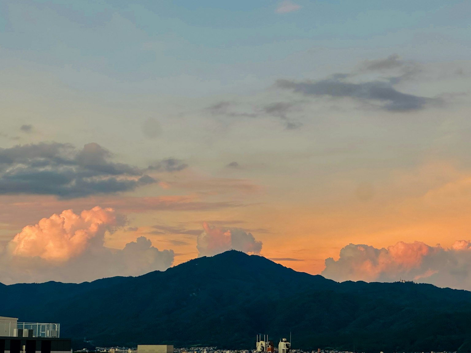 Vista escénica de una montaña y nubes iluminadas por el atardecer