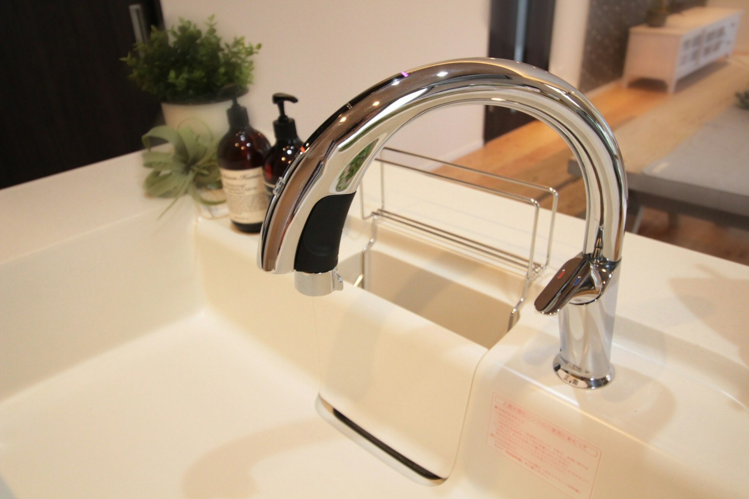 Fregadero elegante con grifo de cromo cerca de una encimera