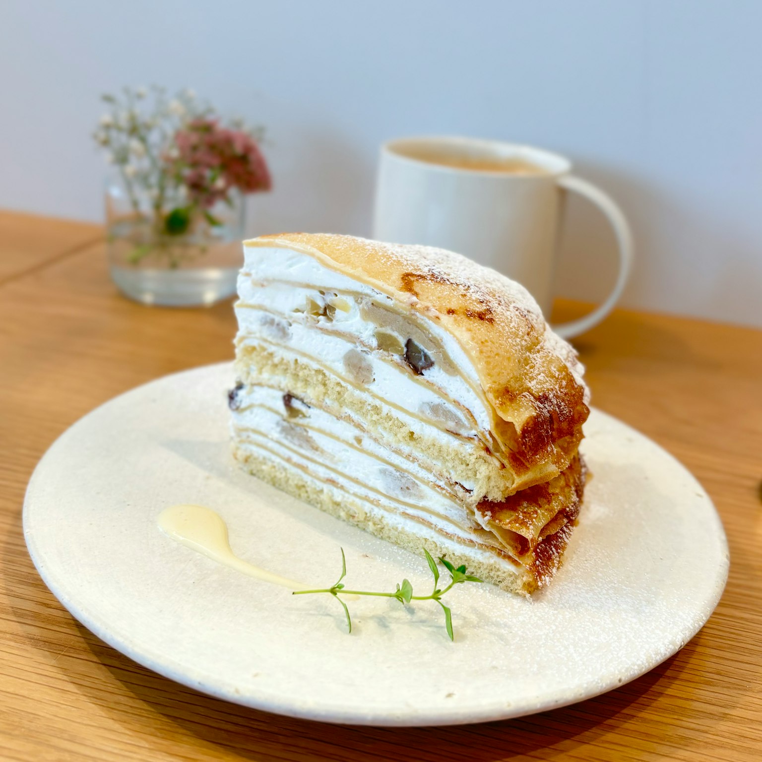 Pastel en capas con crema y nueces servido en un plato con una bebida