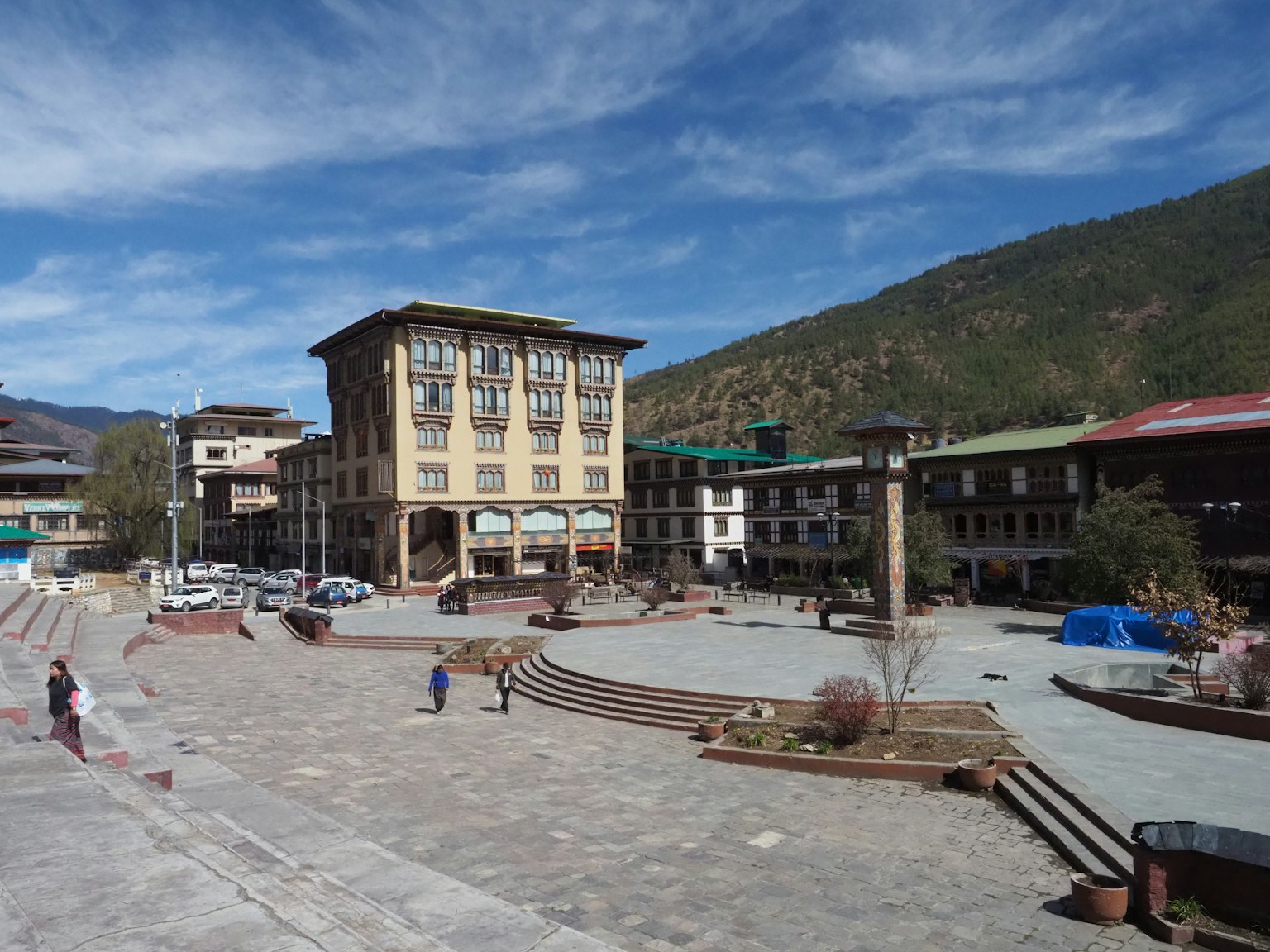 Vista panoramica di una piazza circondata da montagne con architettura moderna e tradizionale