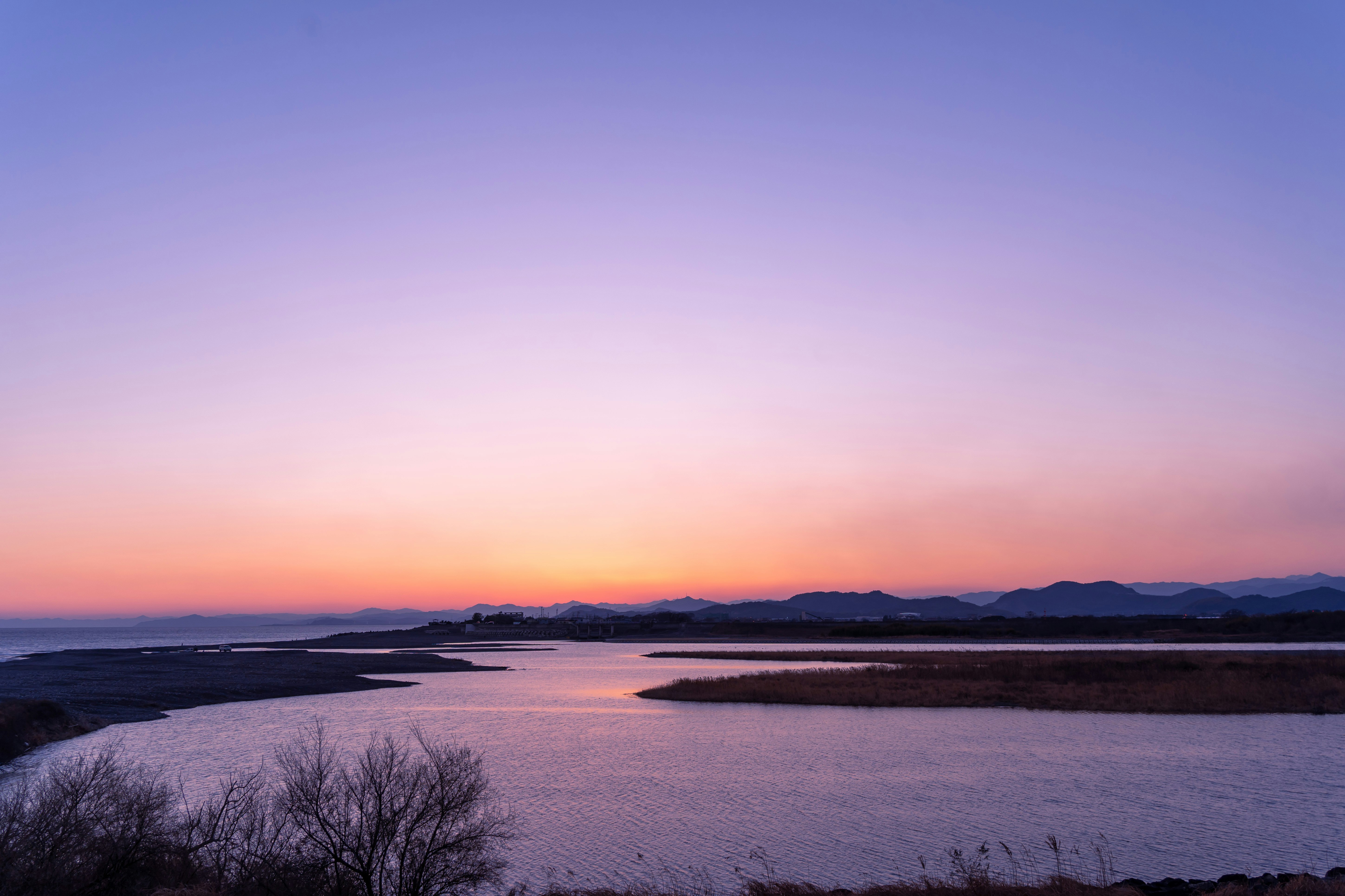 夕暮れの川と遠くの山並みが広がる風景