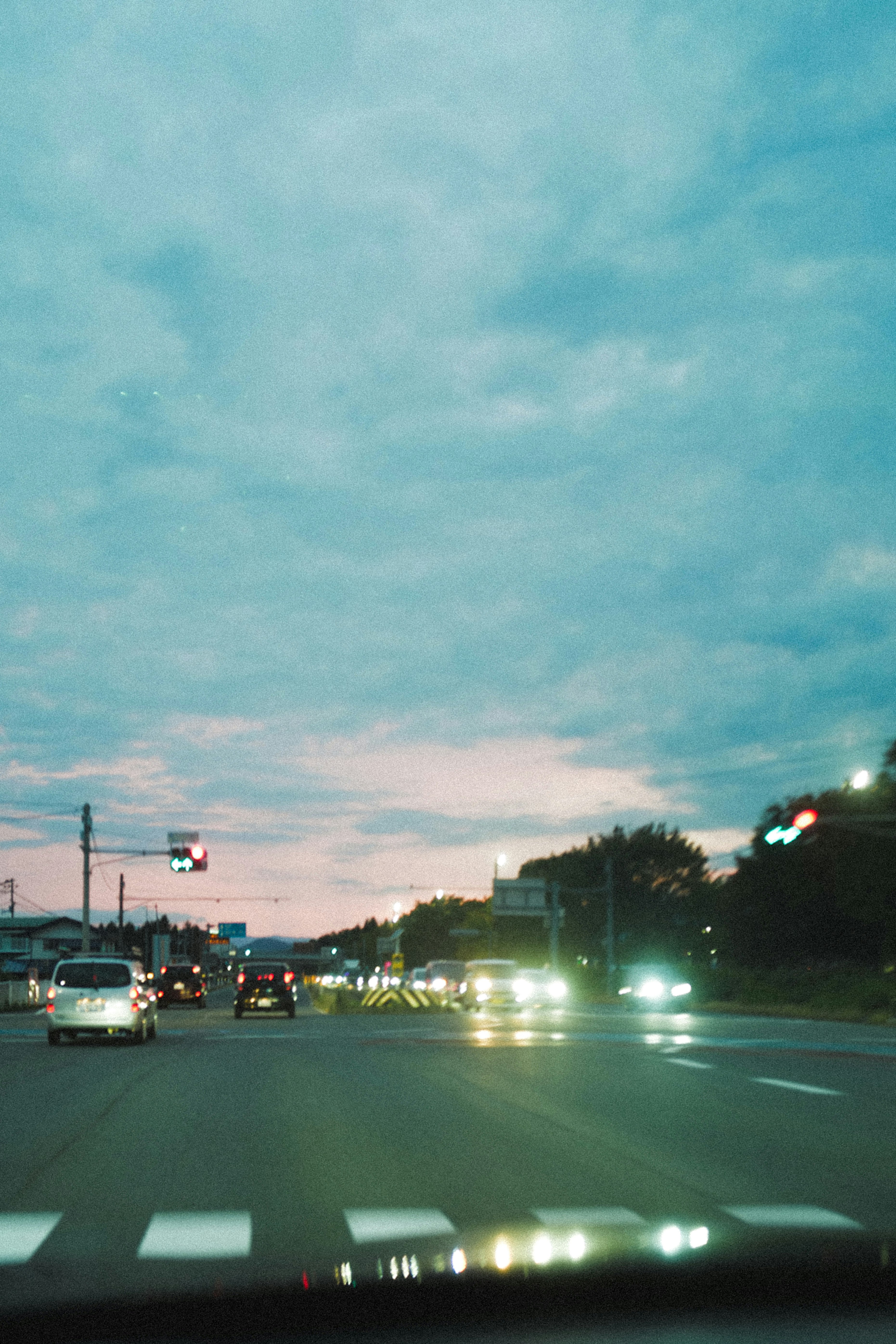 夕暮れの街を走る車のある幹線道路
