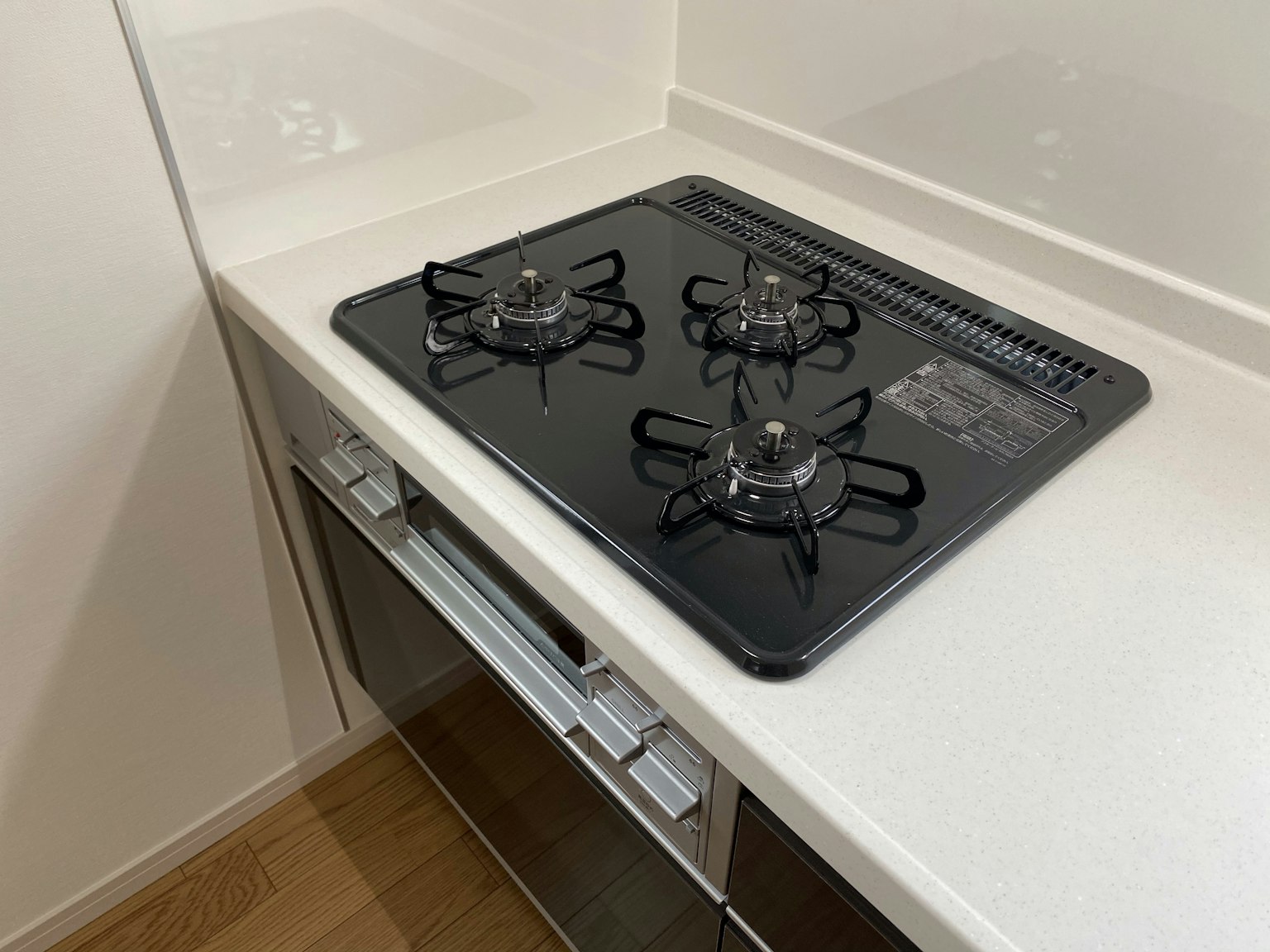 Estufa de gas negra moderna instalada en una cocina sencilla