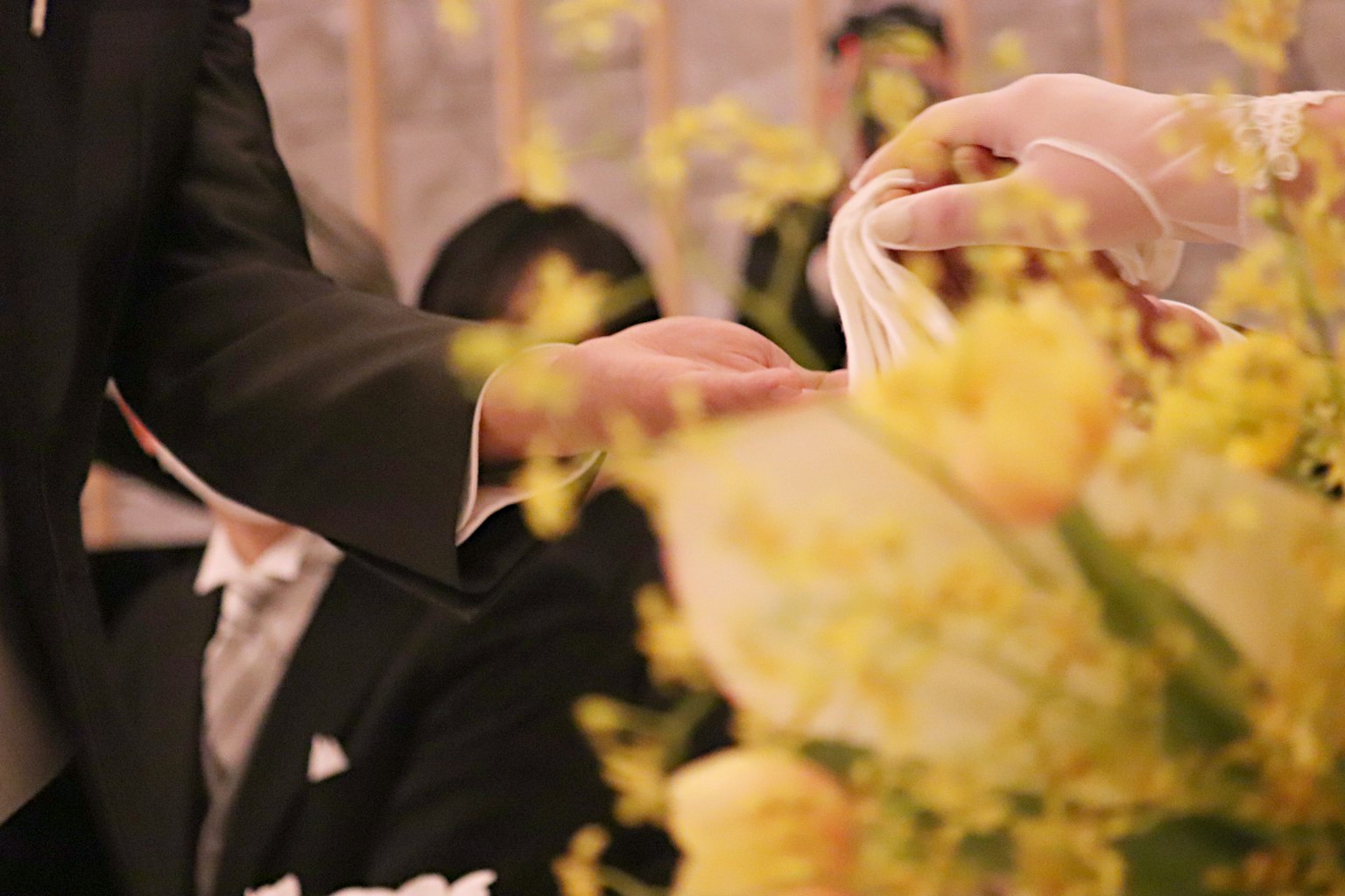Moment of handover at a wedding with yellow flower bouquet