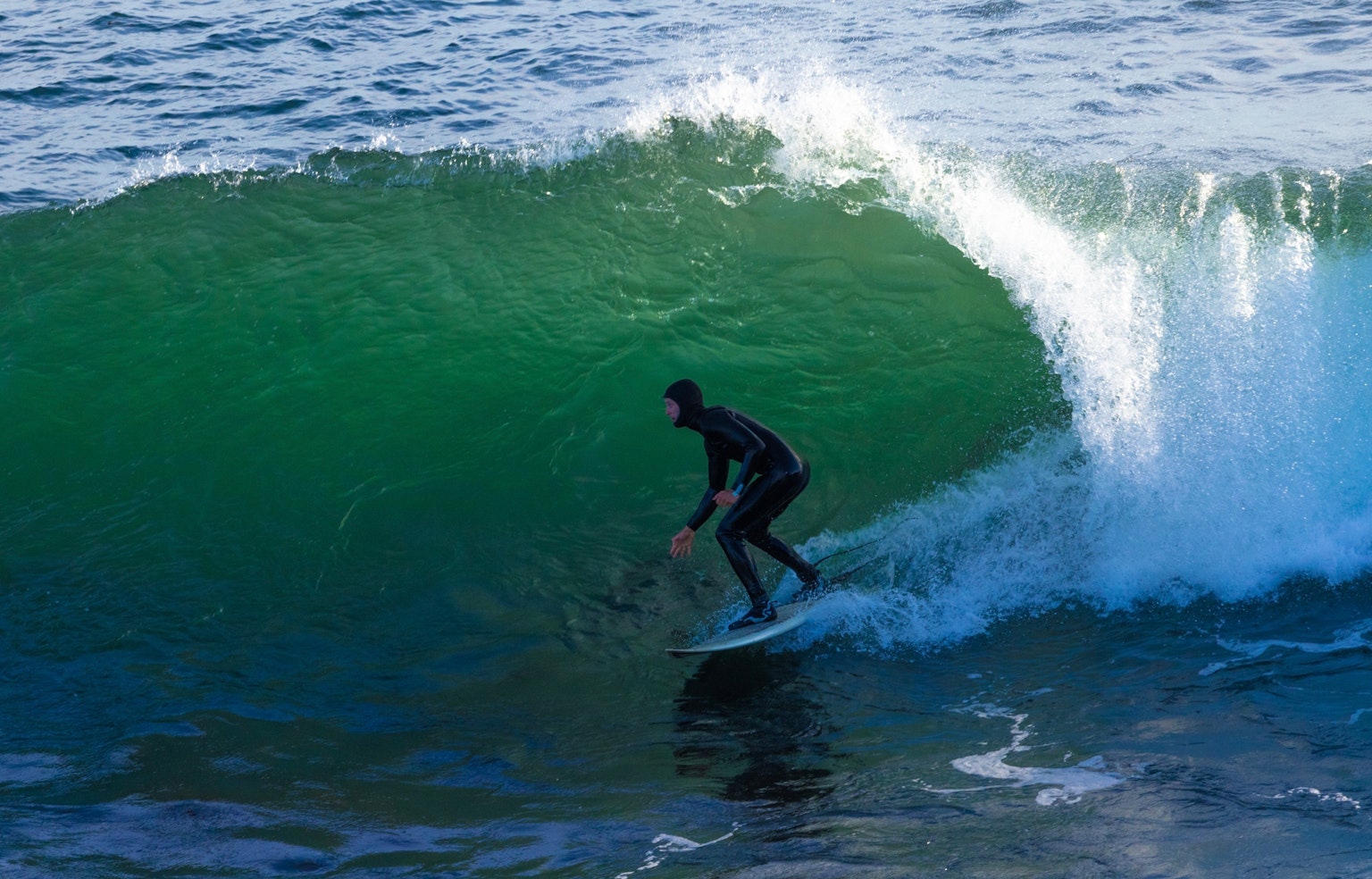 서퍼가 큰 녹색 파도 위에서 균형을 잡고 있습니다