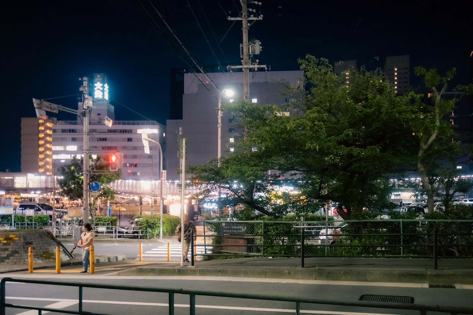 Escena nocturna de una calle de la ciudad iluminada por farolas y edificios