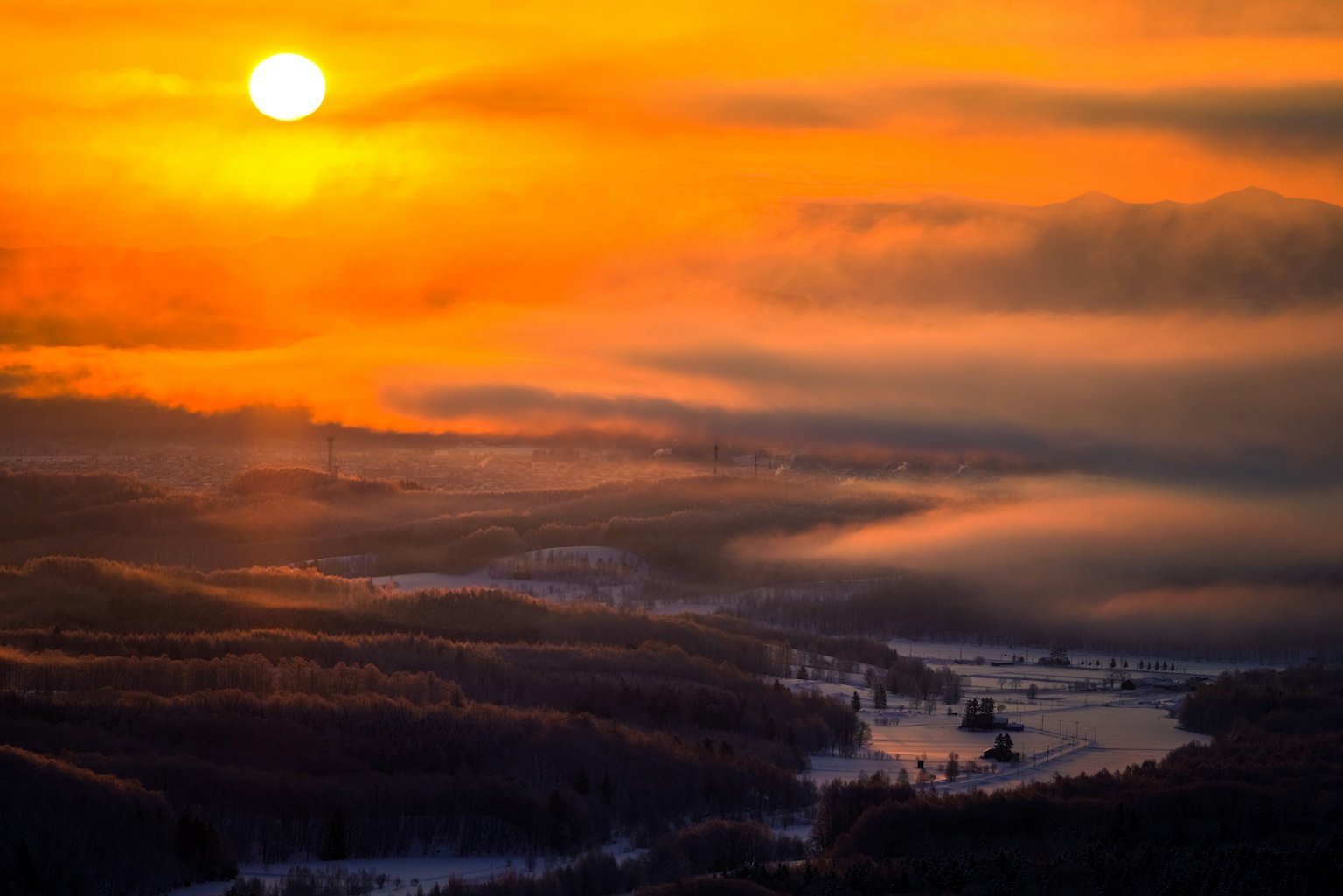 Vista panoramica di un tramonto su un paesaggio fluviale nebbioso