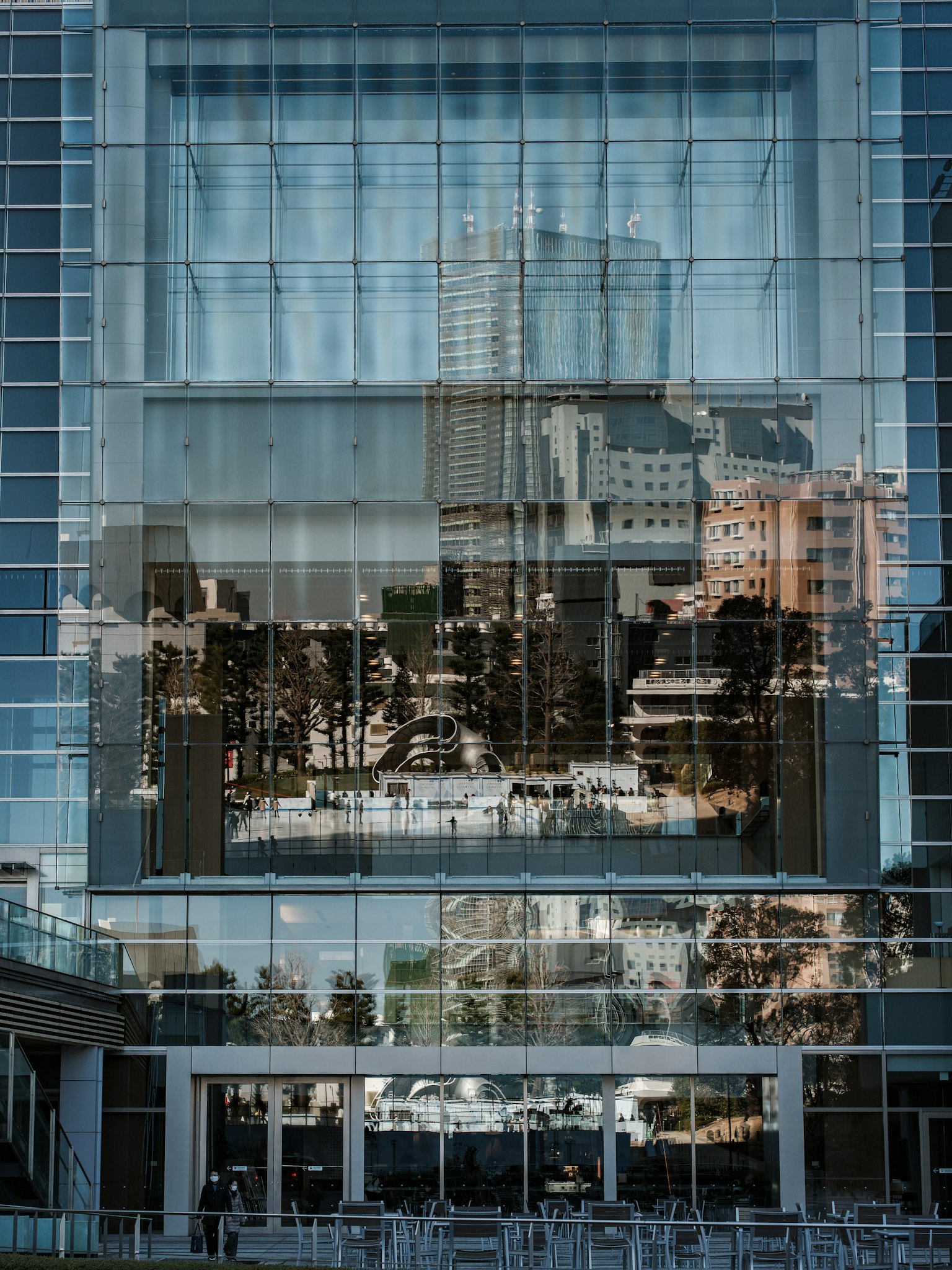 Imagen que captura el reflejo de un edificio moderno con fachada de vidrio