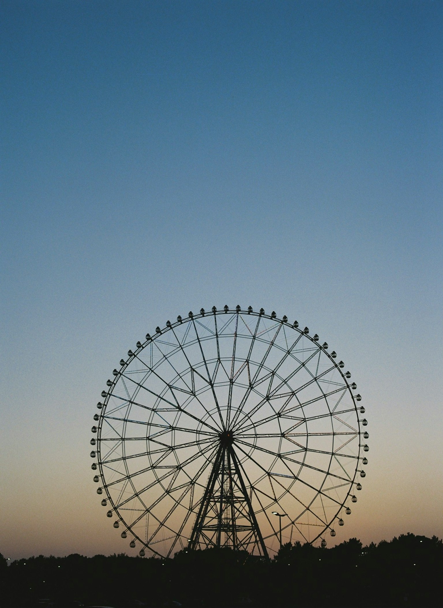 黄昏天空下的摩天轮轮廓