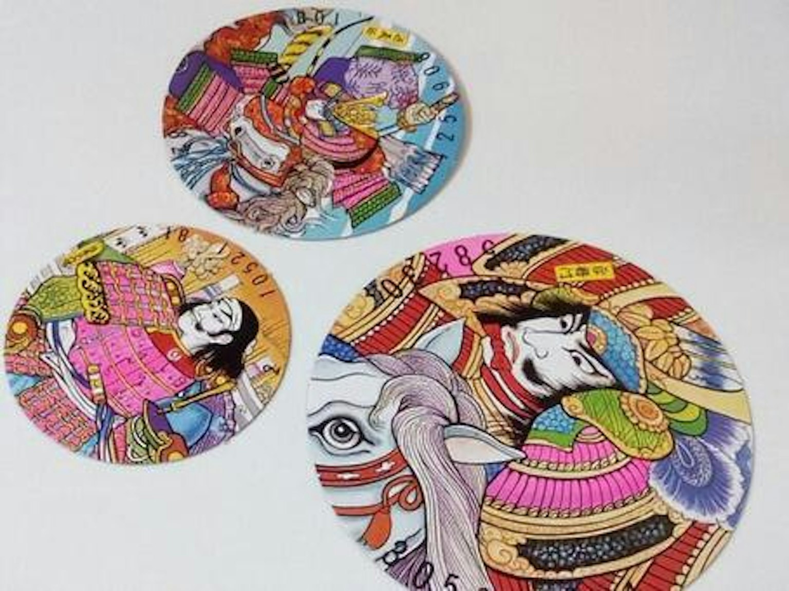 三件圓形藝術作品，具有多彩的圖案和設計