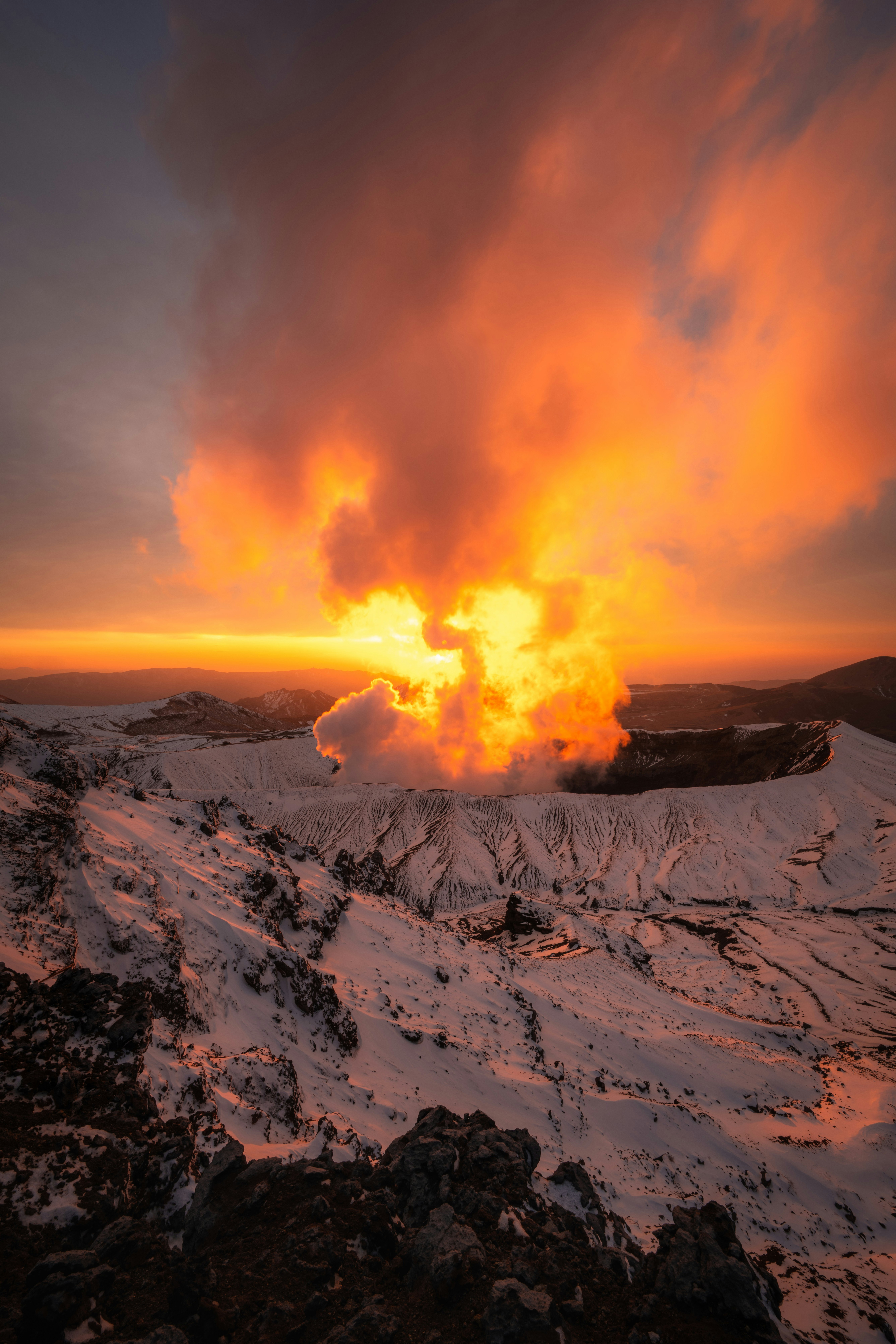 火山噴發火焰與灰燼柱映照在雪地黃昏