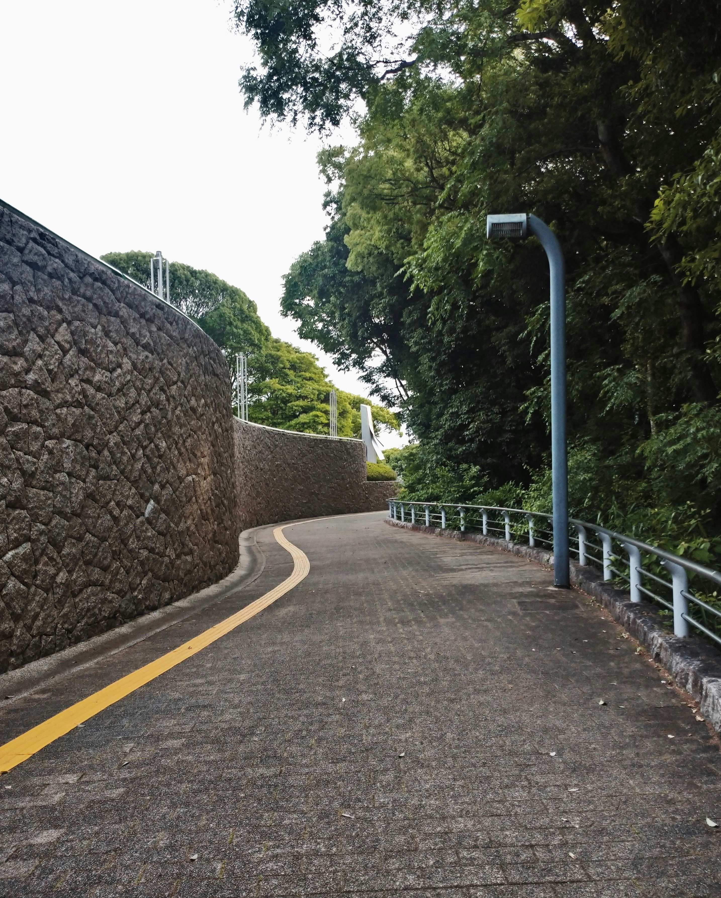 石垣と白い柵のある小径の曲がり道