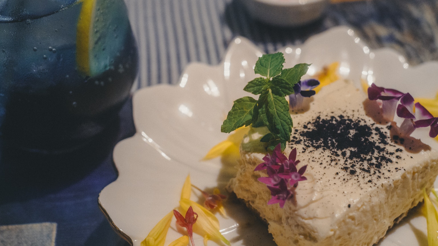 美しいデザートプレートに飾られたケーキとミントの葉と花のトッピング