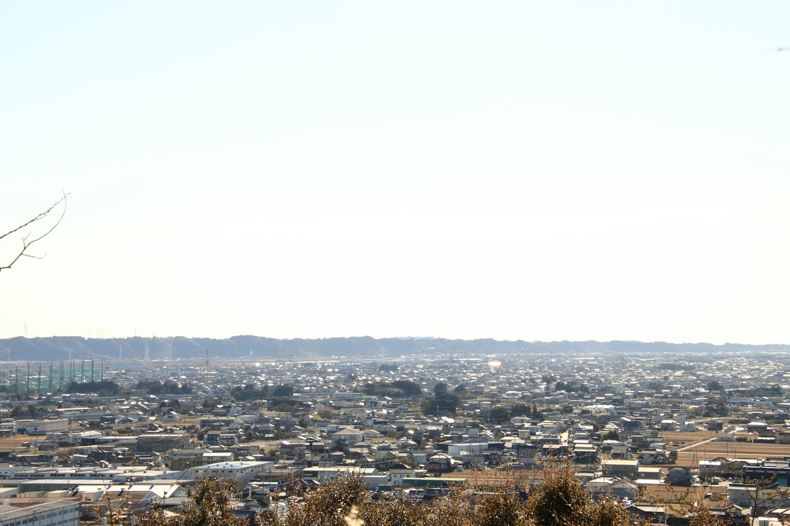 Weitläufige Aussicht auf eine Stadtlandschaft unter einem klaren blauen Himmel