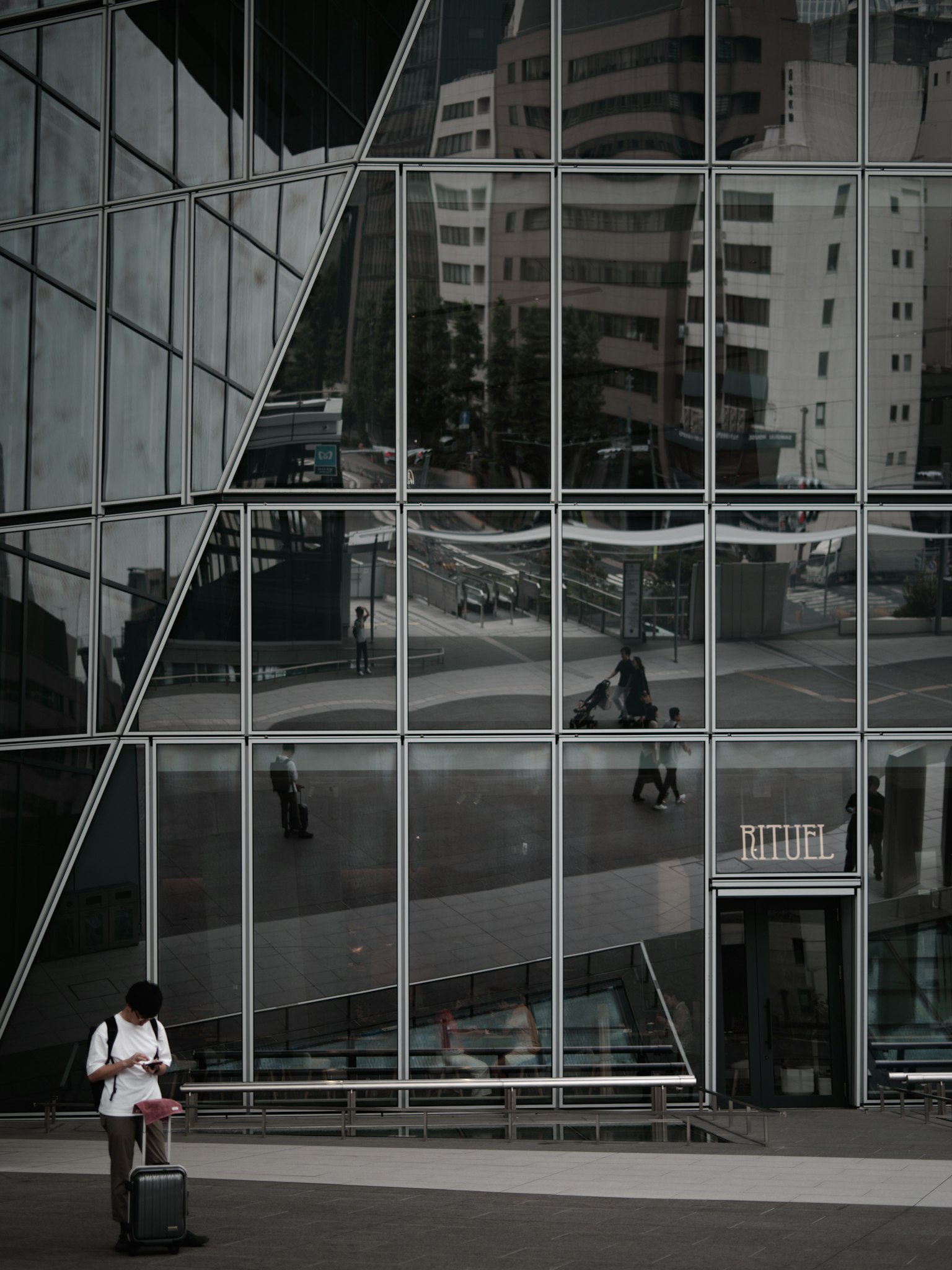 现代建筑玻璃立面反射城市景观和行人