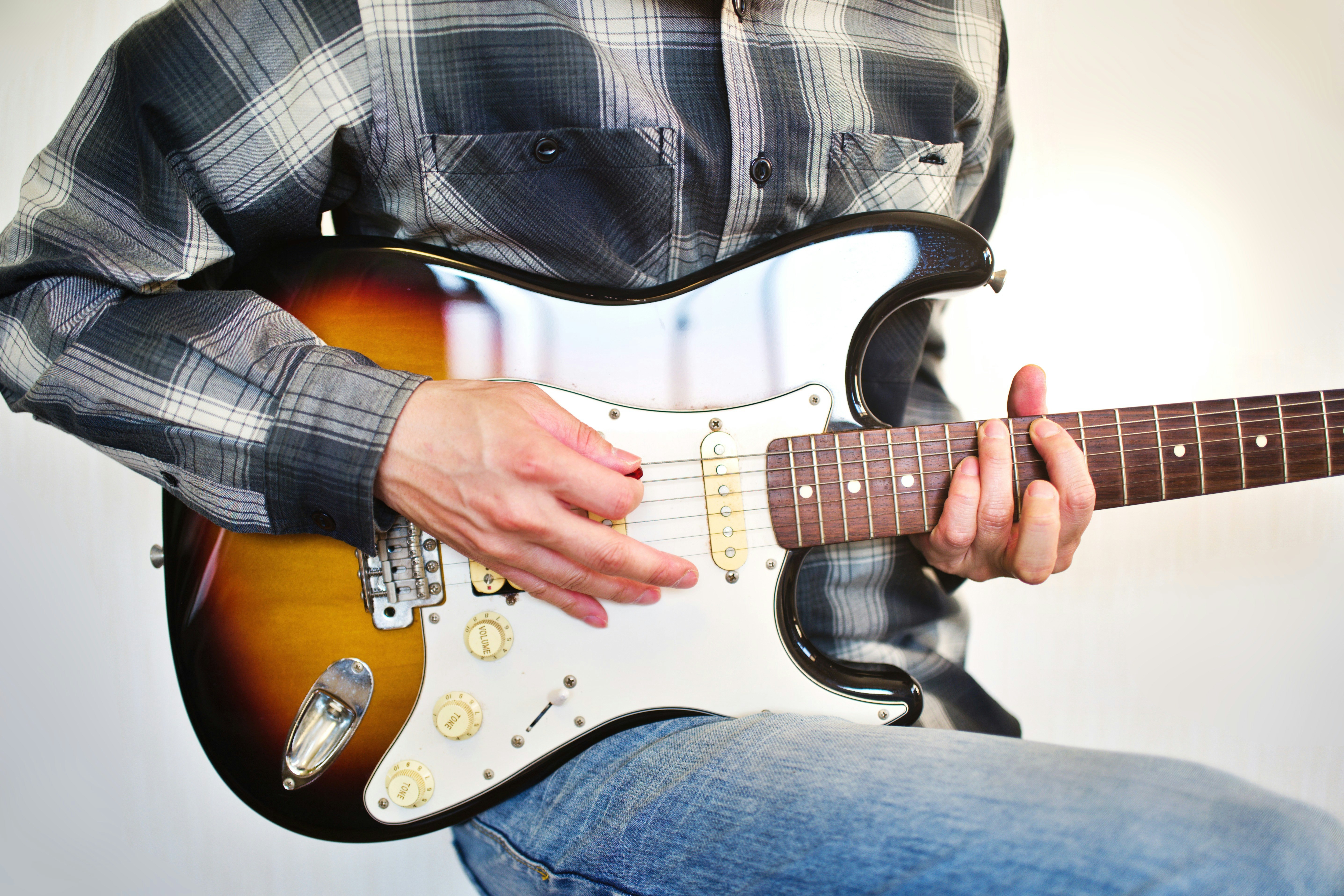 close-up of hands playing an electric guitar