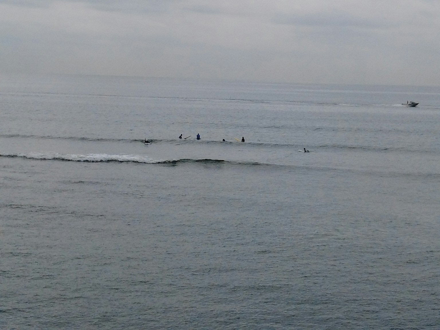 Ruhiges Meer mit mehreren Personen beim Surfen
