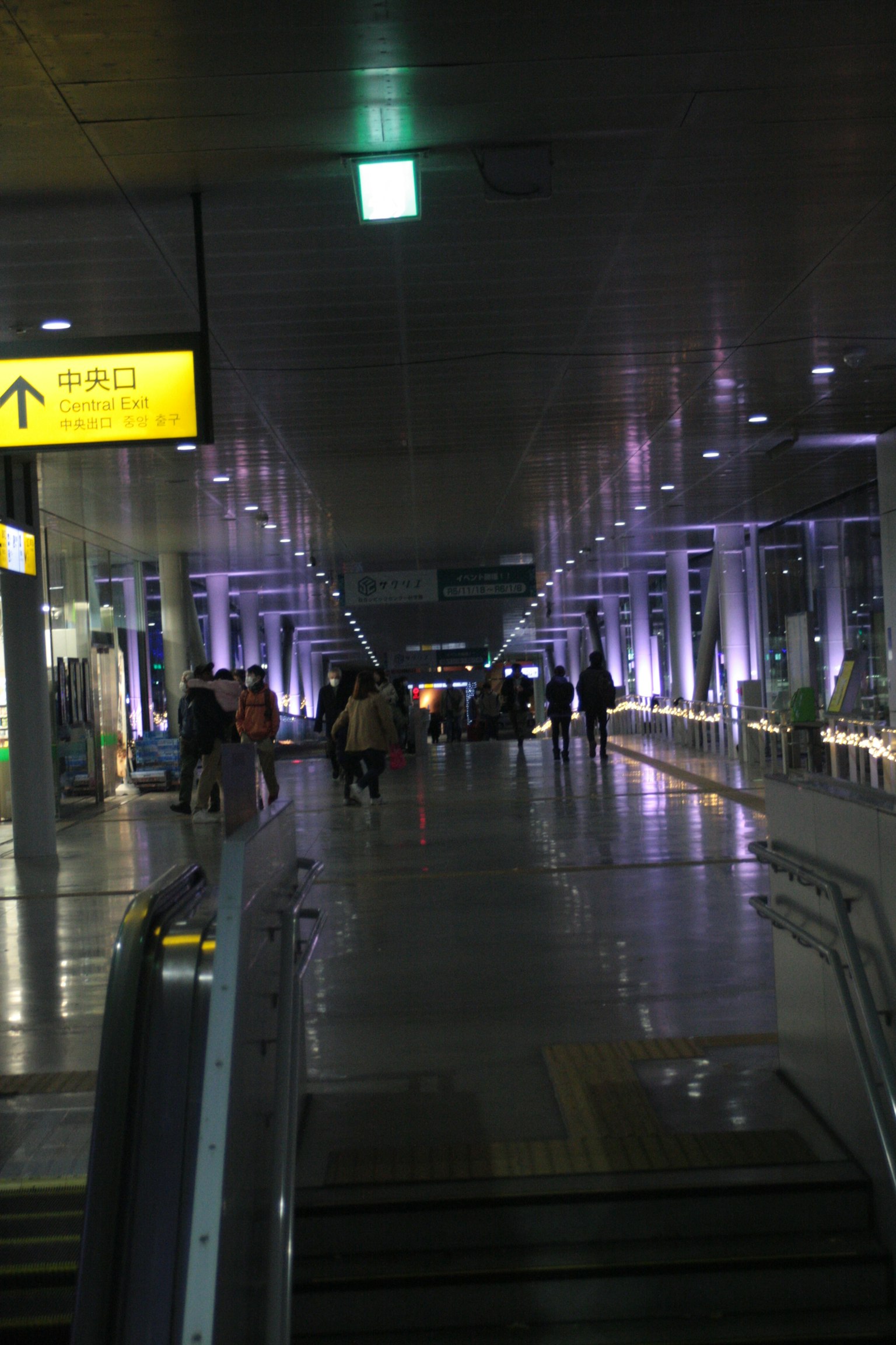 Personas caminando en un pasillo de aeropuerto bien iluminado