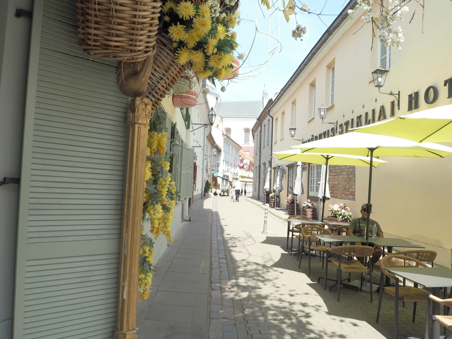Charmante Straßenszene mit Blumen und Außenbereich von Cafés