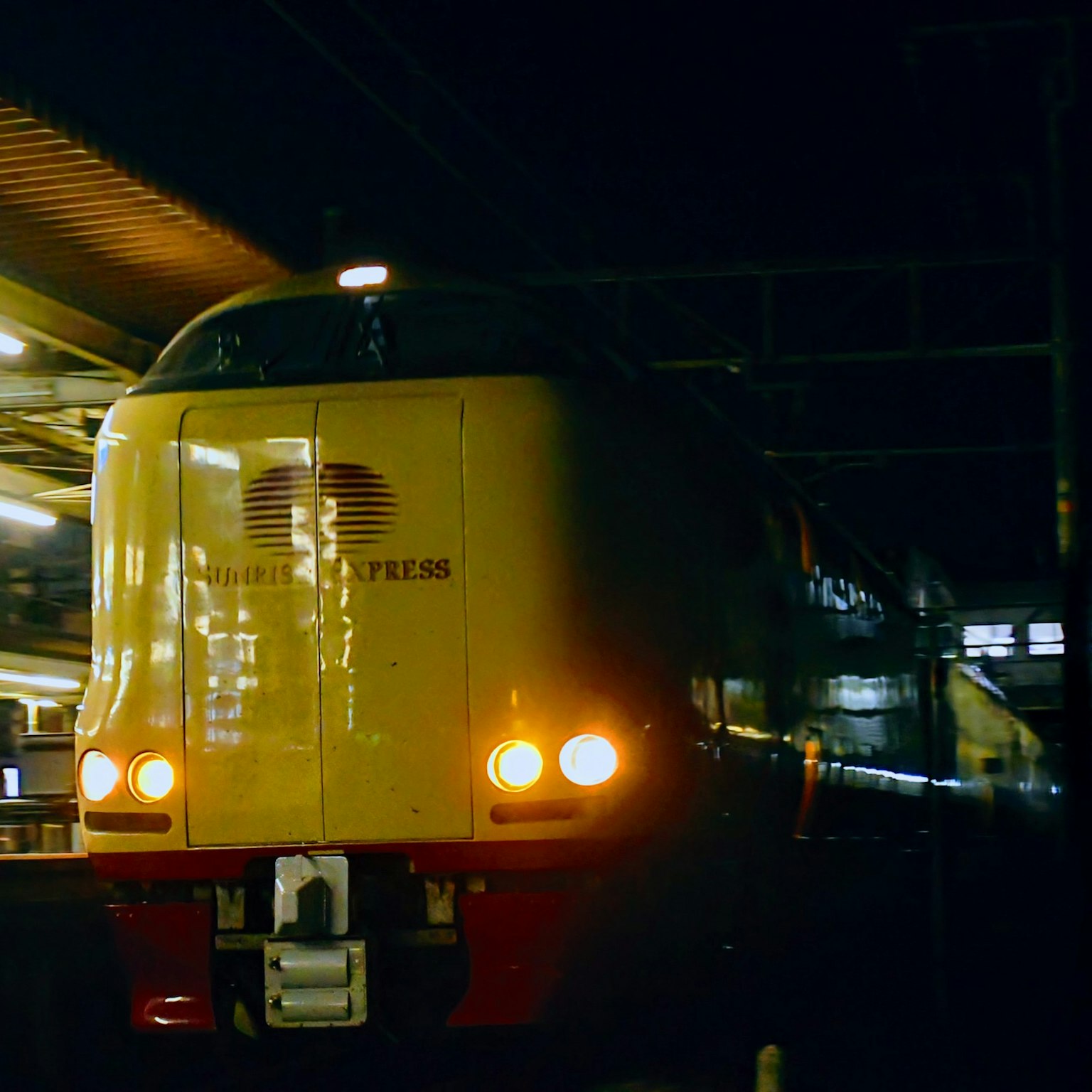 Train express jaune arrêté à la station de nuit