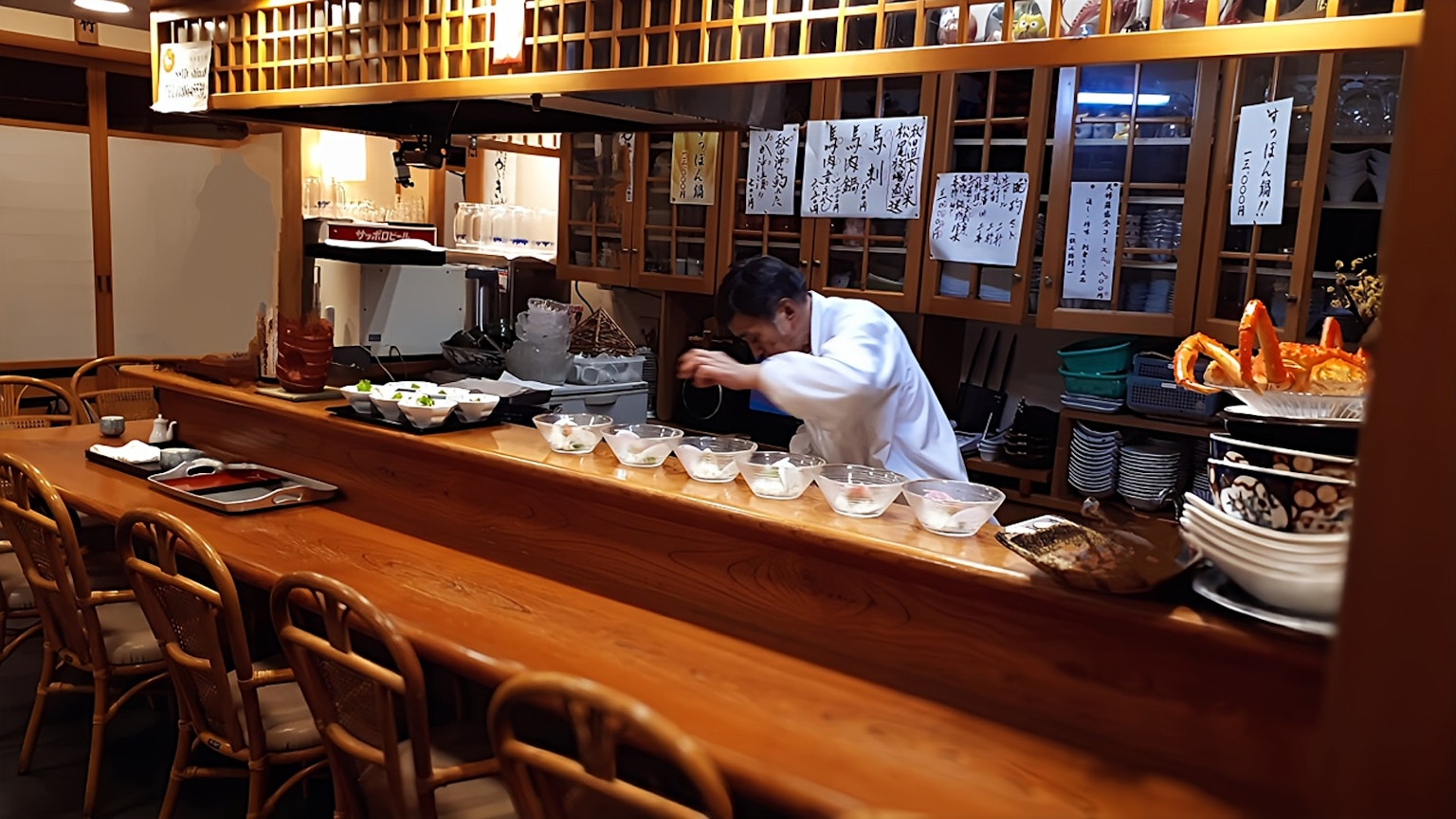 Koch, der Gerichte an der Theke eines japanischen Restaurants zubereitet