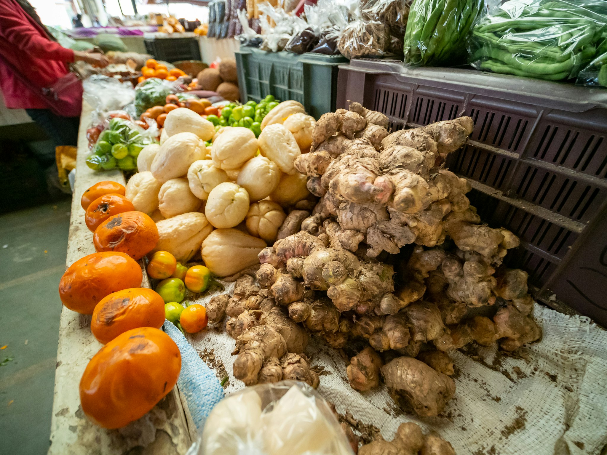 fresh vegetables and ginger piled at a market stall