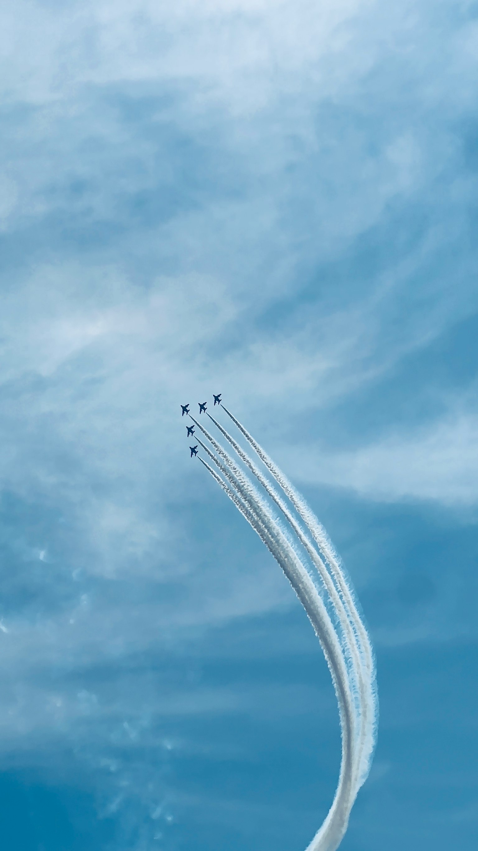 Flugzeuge, die weiße Rauchspuren in einem blauen Himmel hinterlassen