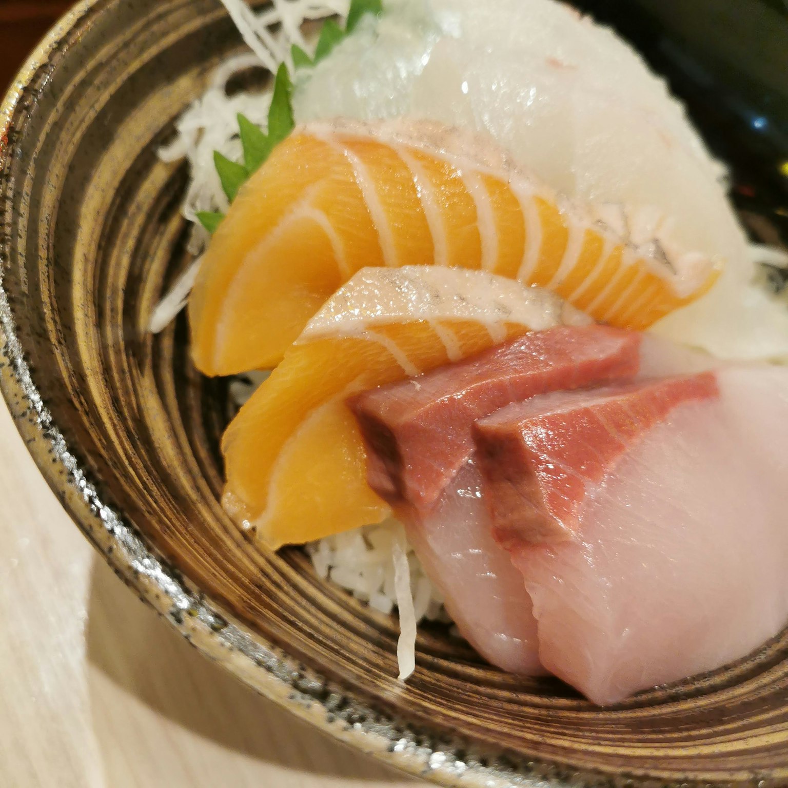 Eine schöne Anordnung von frischem Sashimi in einer dekorativen Schüssel serviert