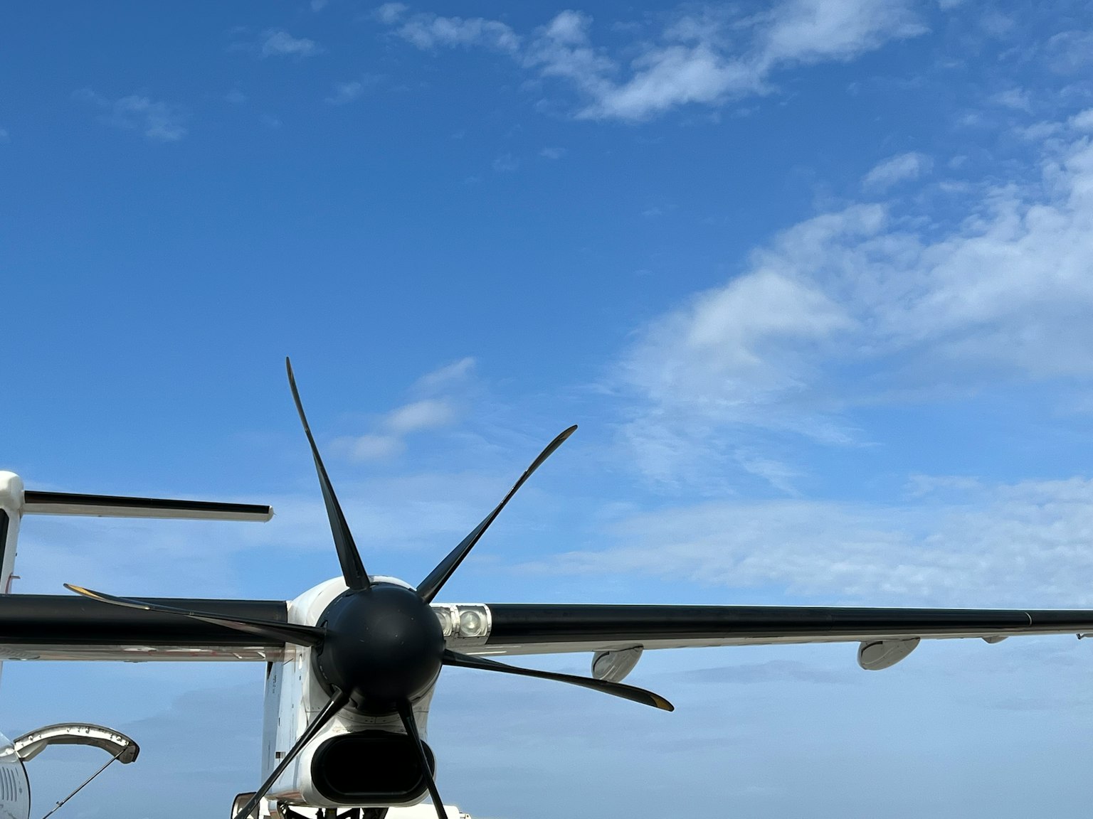 Pemandangan belakang pesawat propeller dengan langit biru