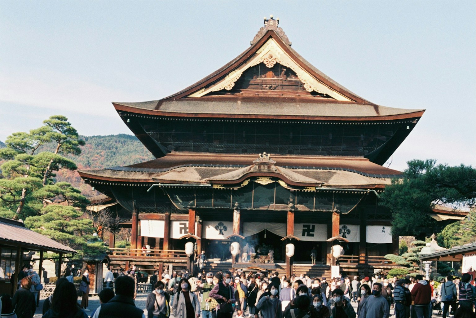 Historic temple with traditional Japanese architecture and crowd of visitors